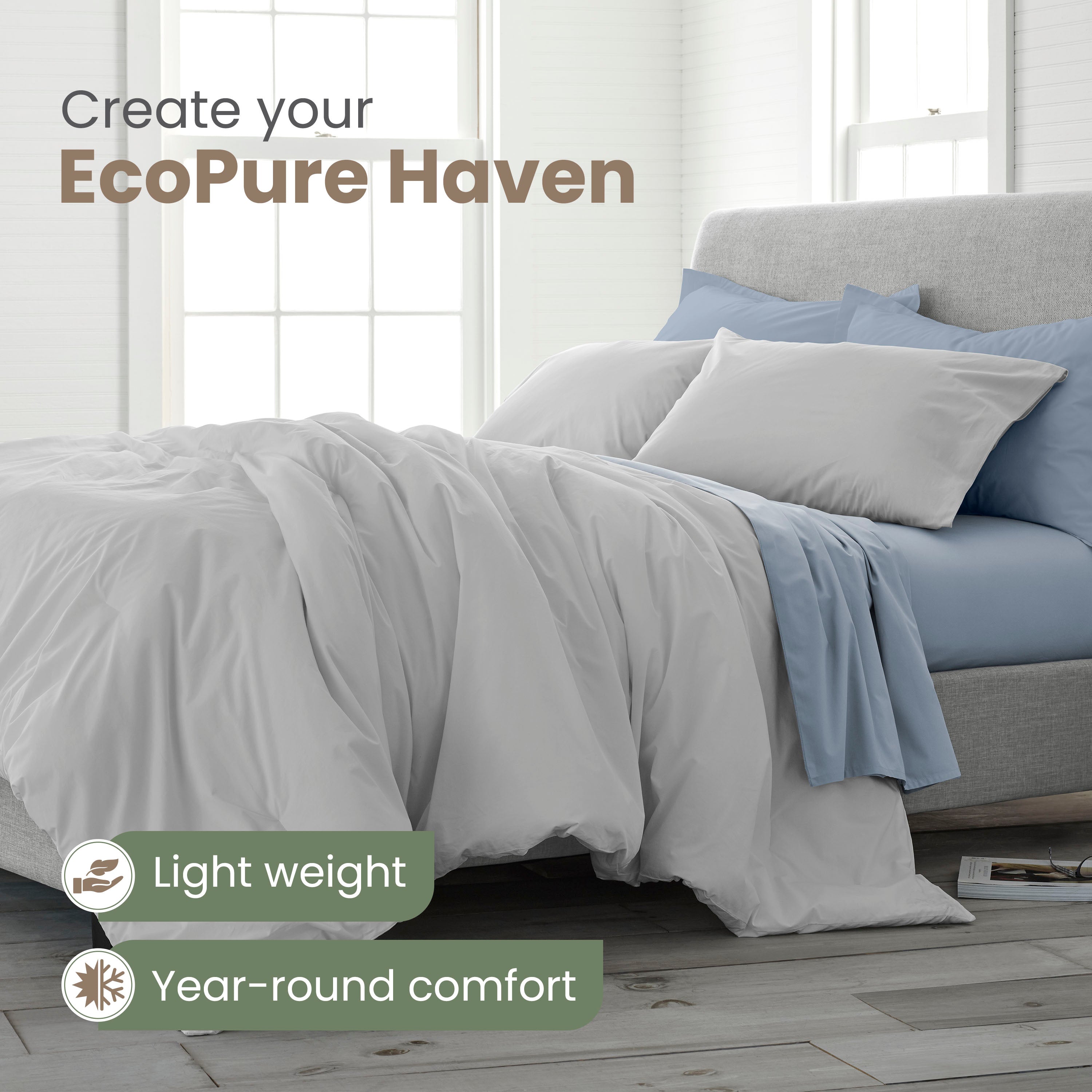 Light gray comforter set with matching pillows and blue accents on a bed in a bright, airy room.