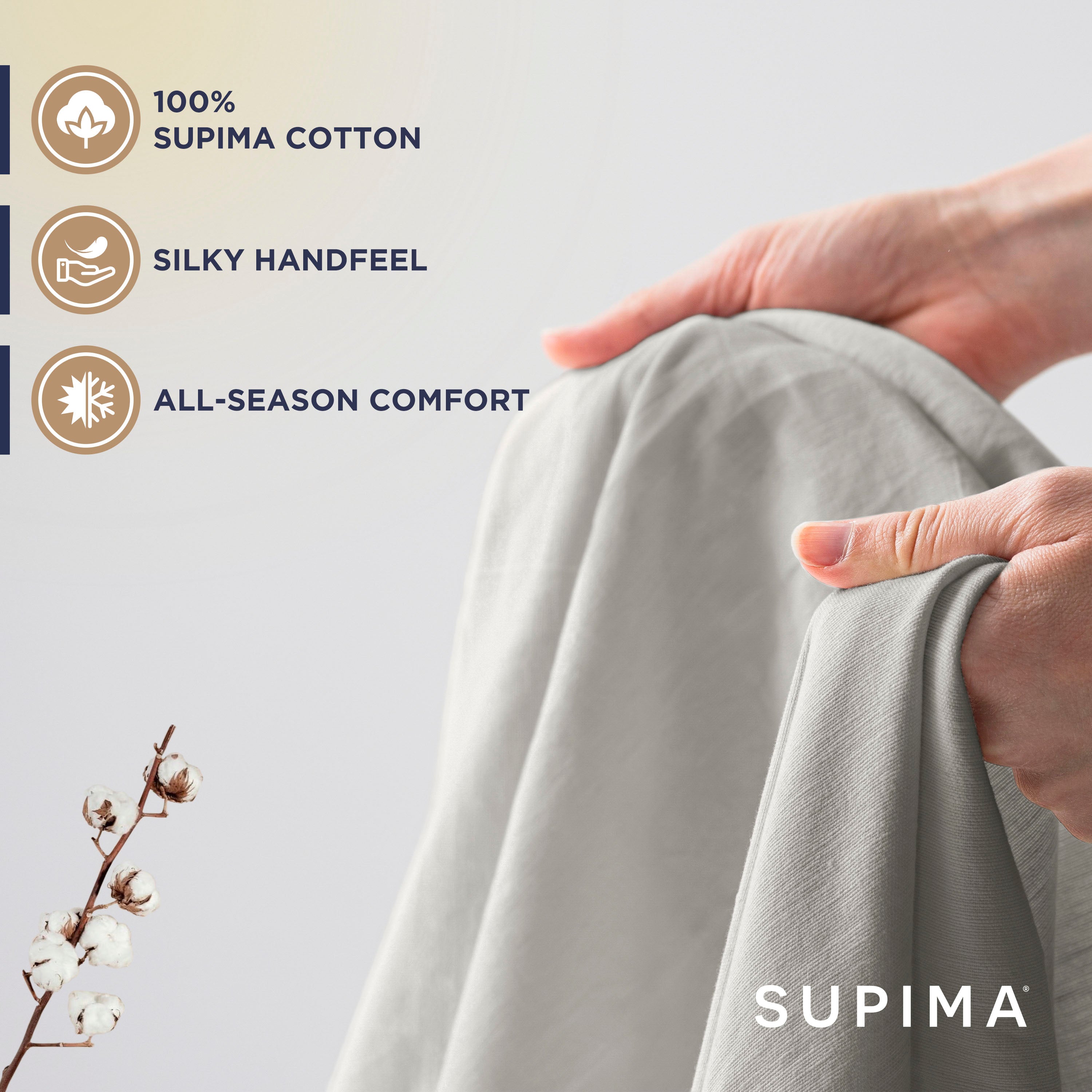 Hands holding a light gray sheet, with a cotton branch visible in the foreground.