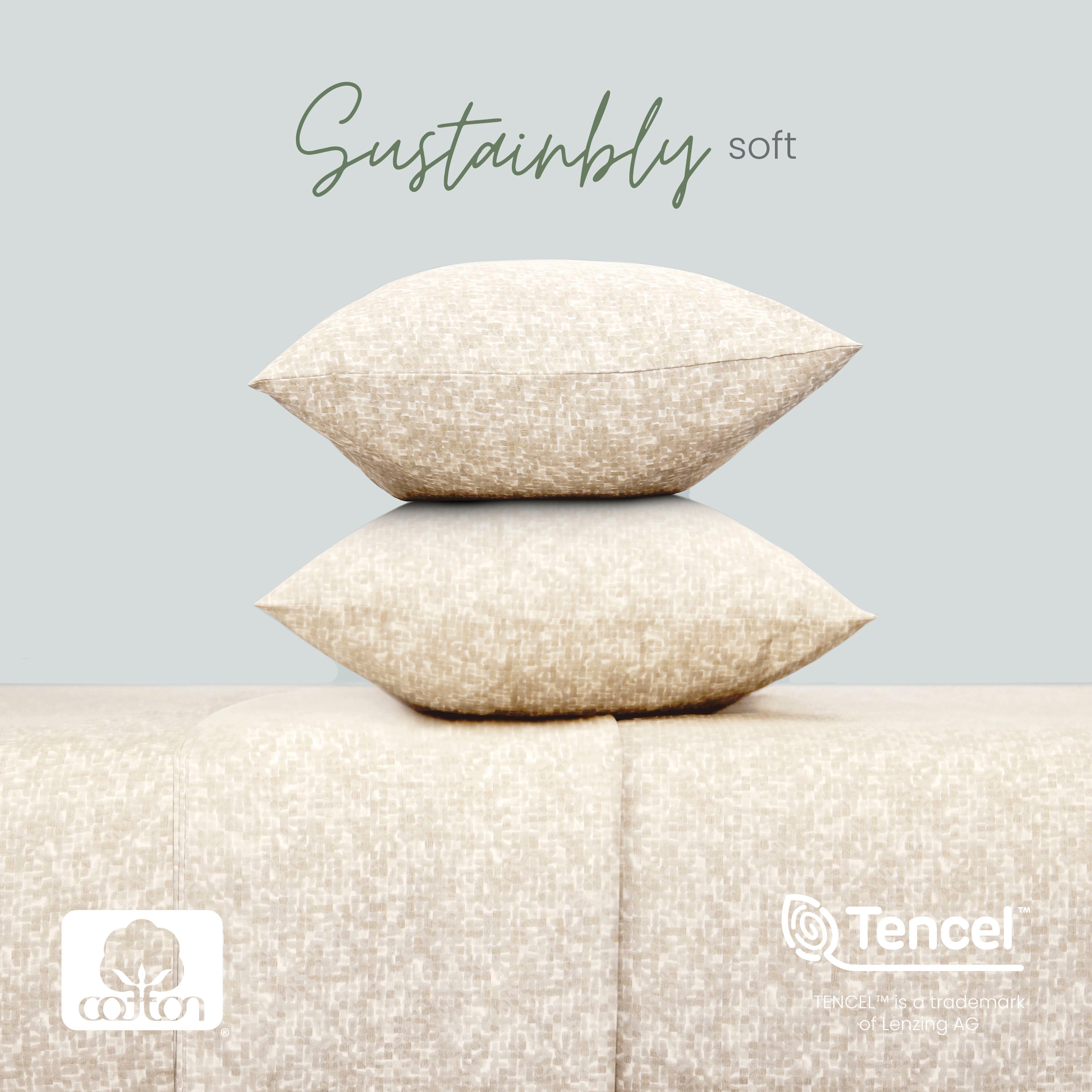 Two linen pillows stacked on a textured surface with 'Sustainably soft' text and Tencel logo.