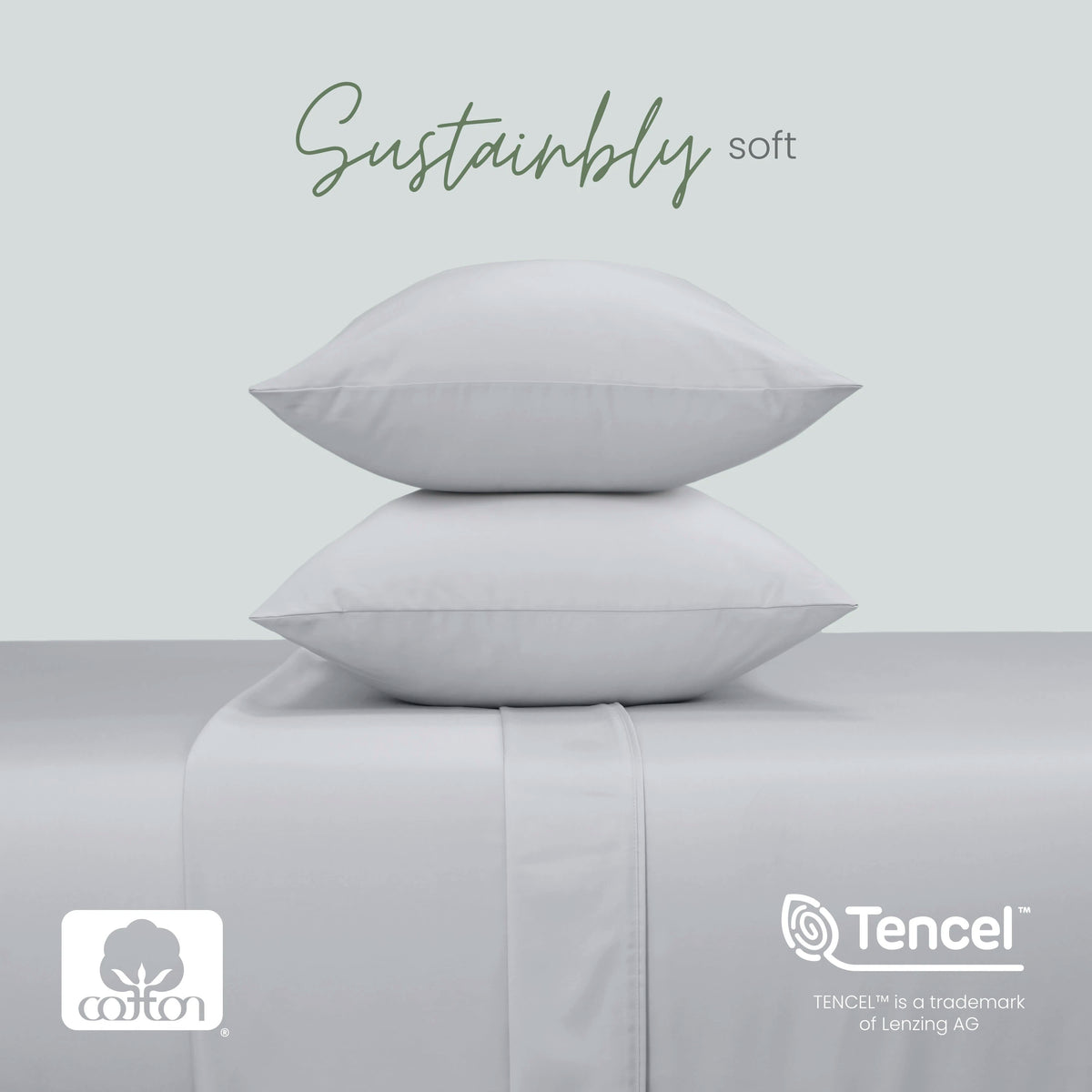 Two grey pillows stacked on a matching upholstered surface, with the words 'Sustainably soft' above. Cotton and Tencel logos appear at the bottom, with a pale gray background.