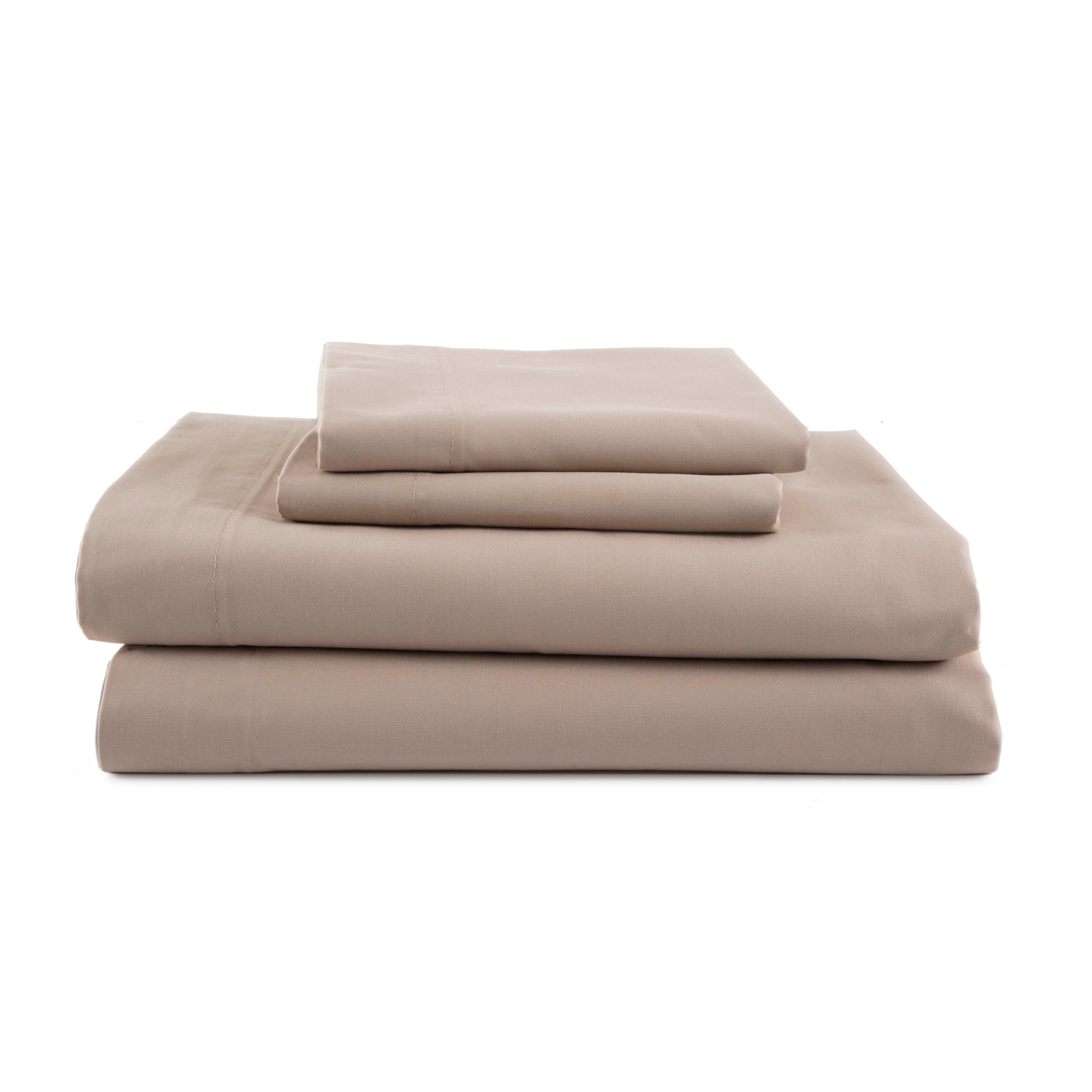 Four pieces of beige sheets stacked neatly, including fitted and flat sheets with pillowcases.