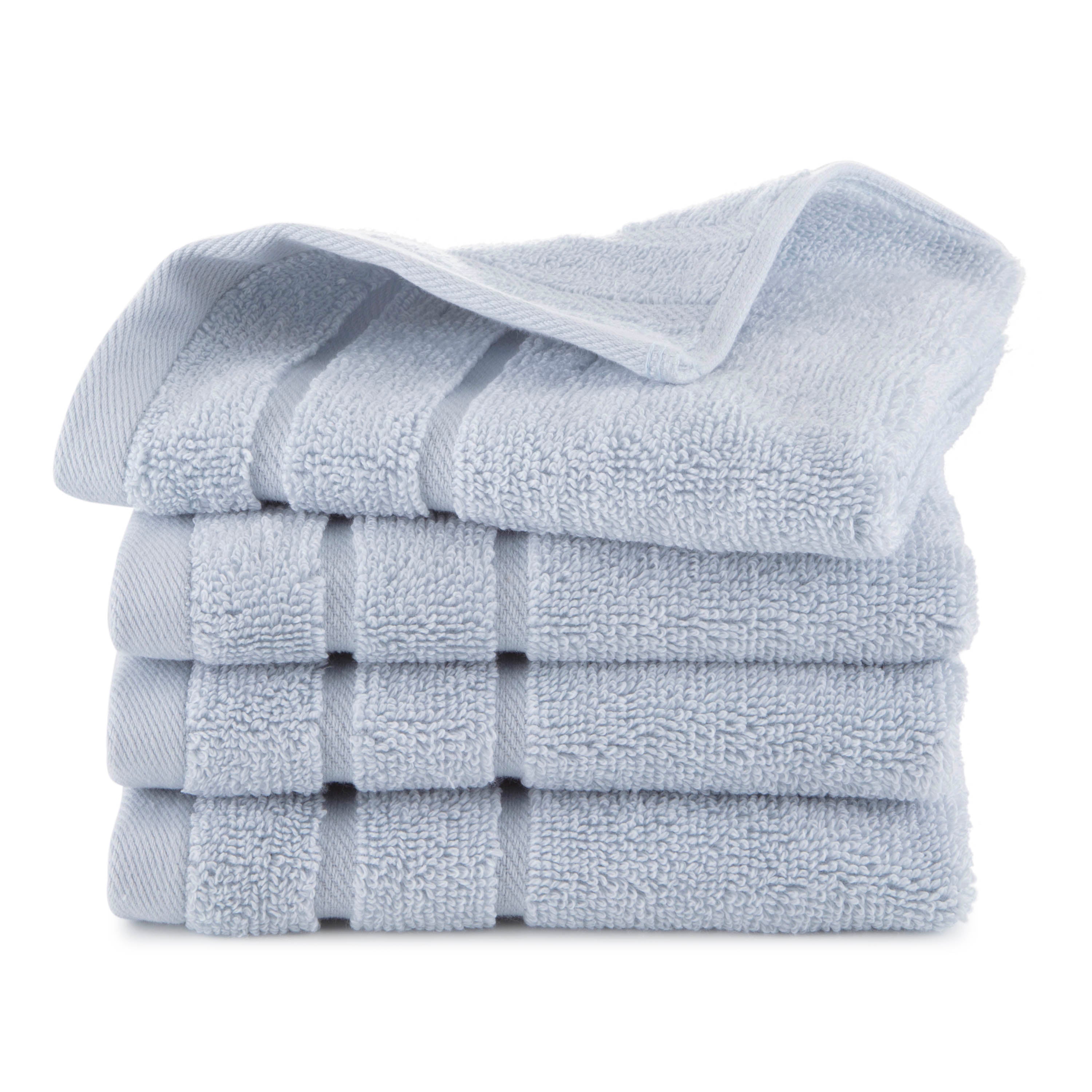Four stacked light blue wash cloths with a textured surface.
