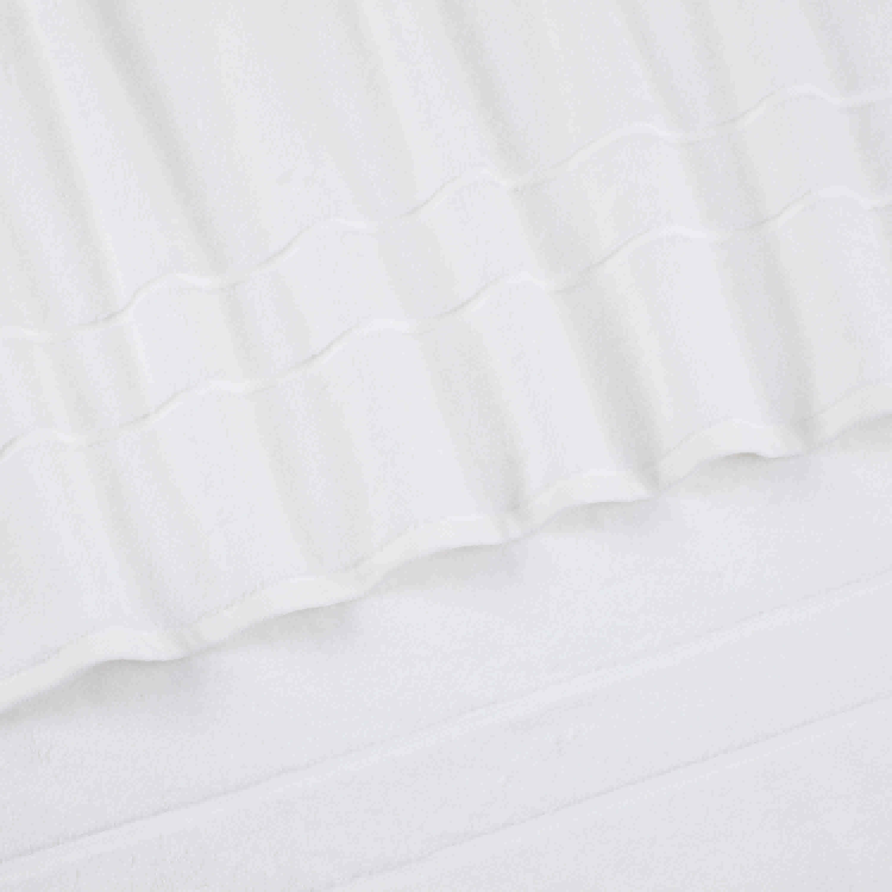 Two white bath towels with a textured design and smooth edges, laid flat on a light surface.