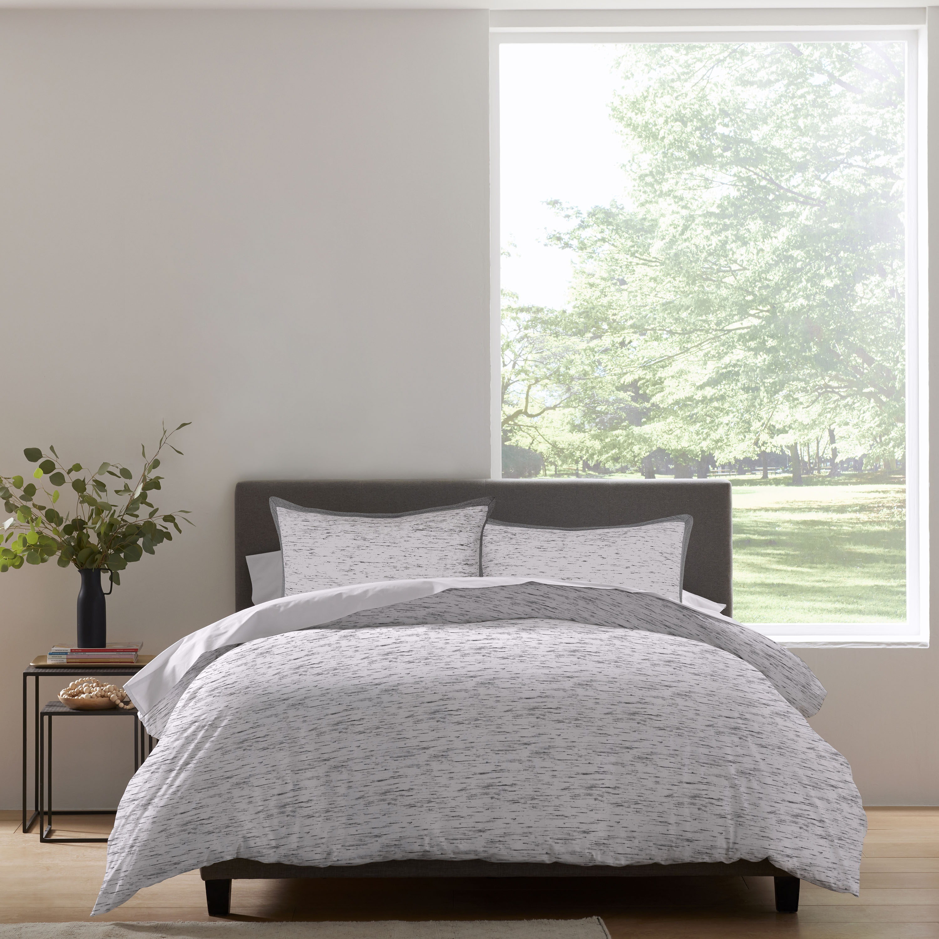 Comforter set featuring a gray and white speckled pattern, paired with matching pillow shams on a bed.