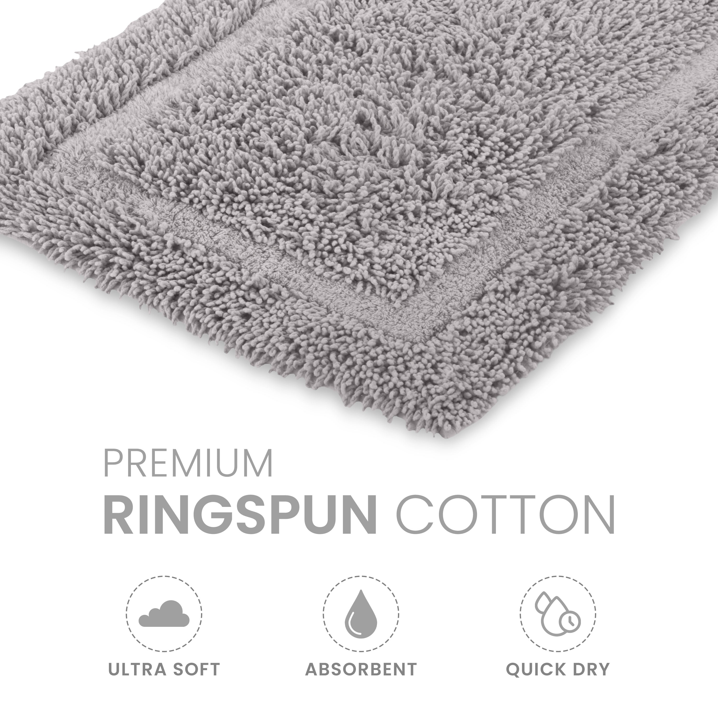 Gray bath rug with a textured surface and bordered design, made from ringspun cotton.