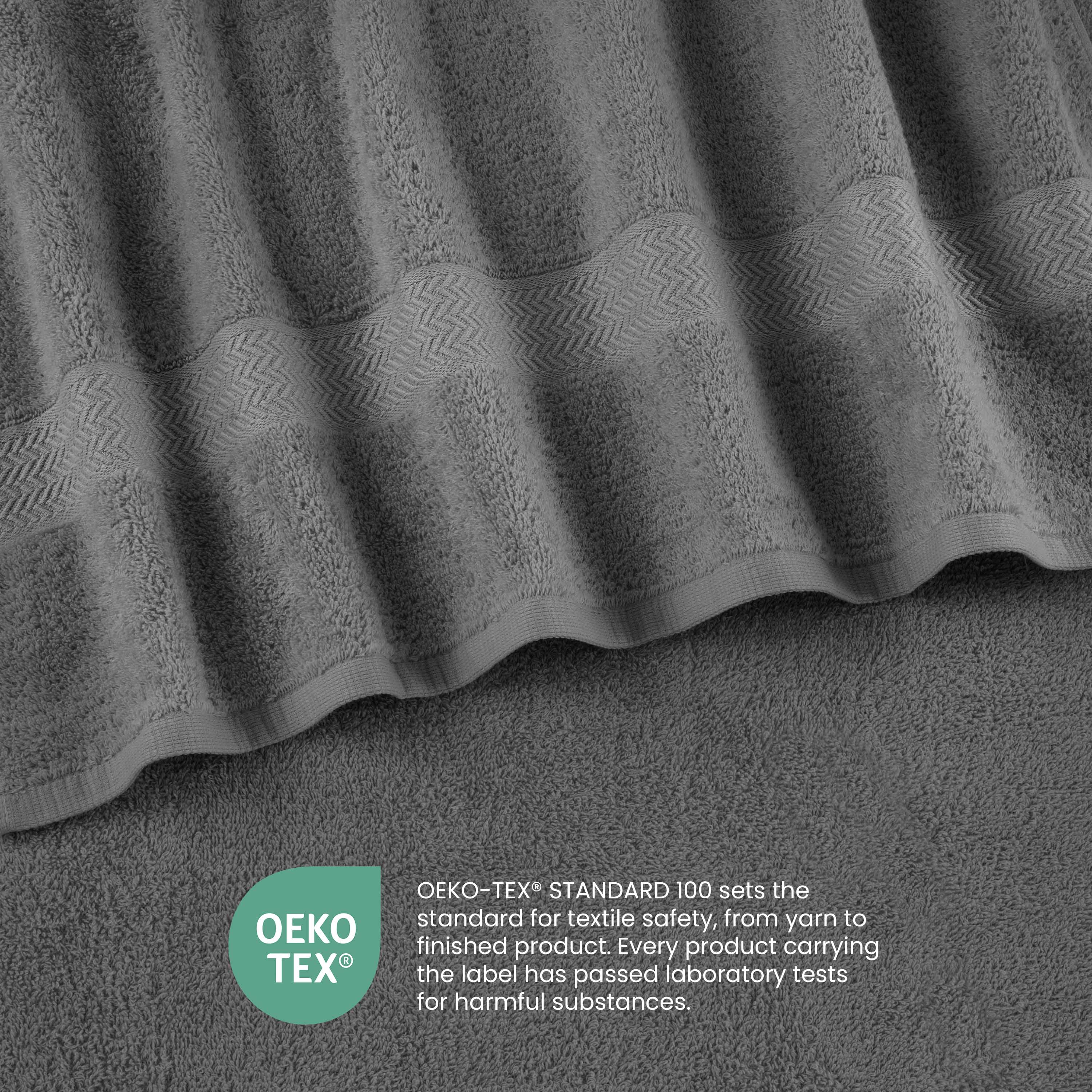 Gray towels with a textured pattern and a label indicating Oeko-Tex certification for textile safety.
