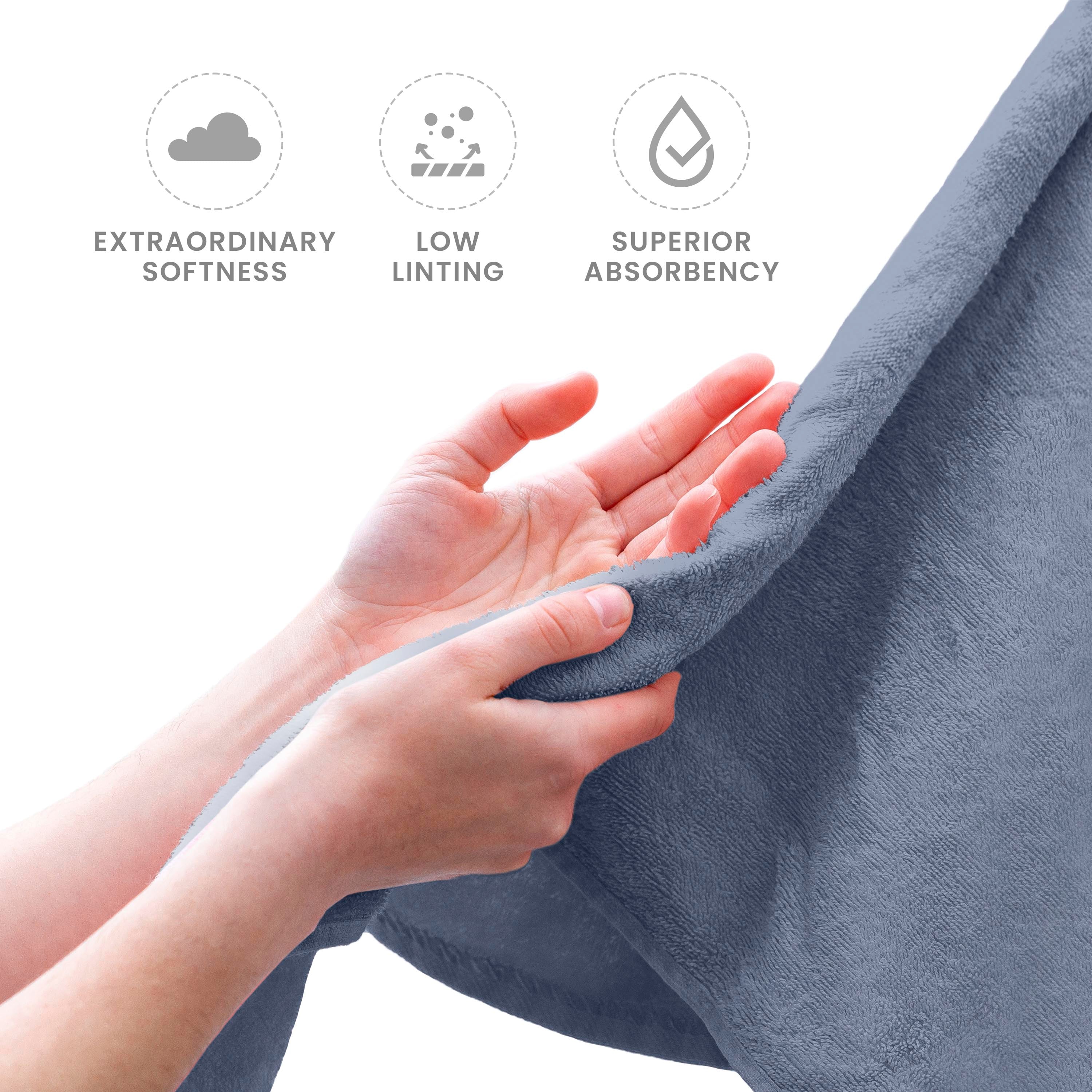 Hands holding a soft, gray towel, showcasing its texture and quality.