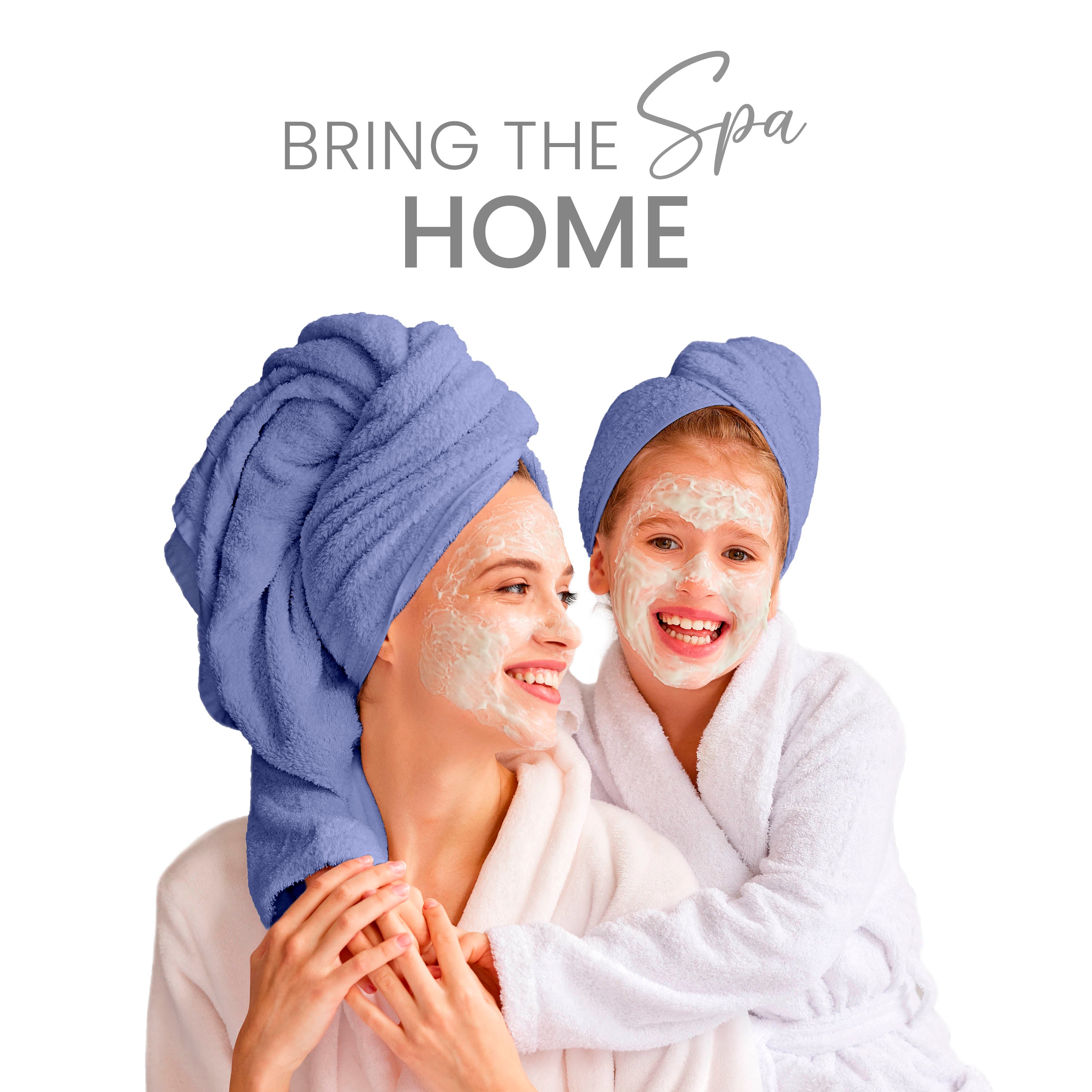 Two people with towels on their heads, smiling and wearing facial masks, dressed in bathrobes.