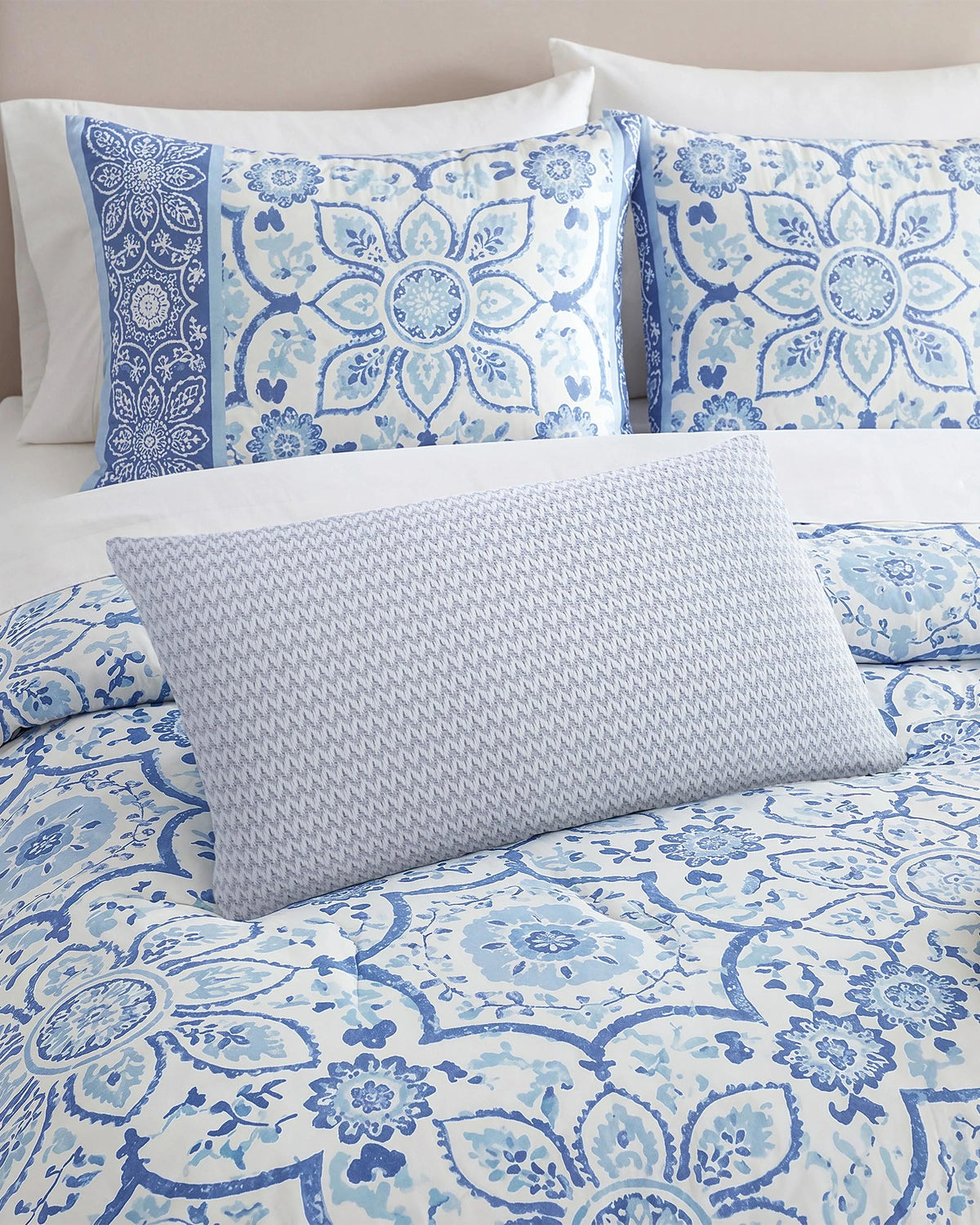 Blue decorative pillow on a bed.