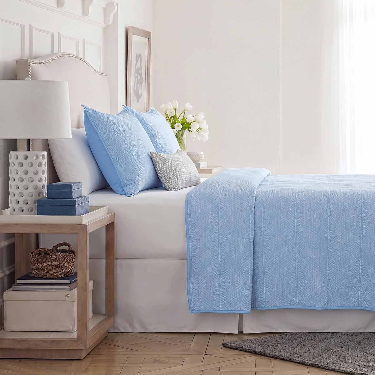 Side view of blue coverlet and euros on the bed.