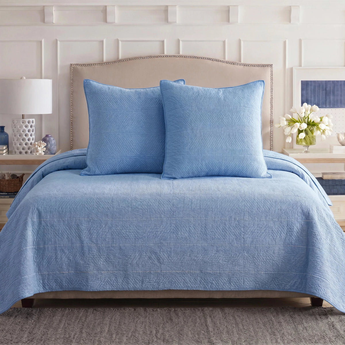 Blue Southern Tide quilt and shams on a bed.