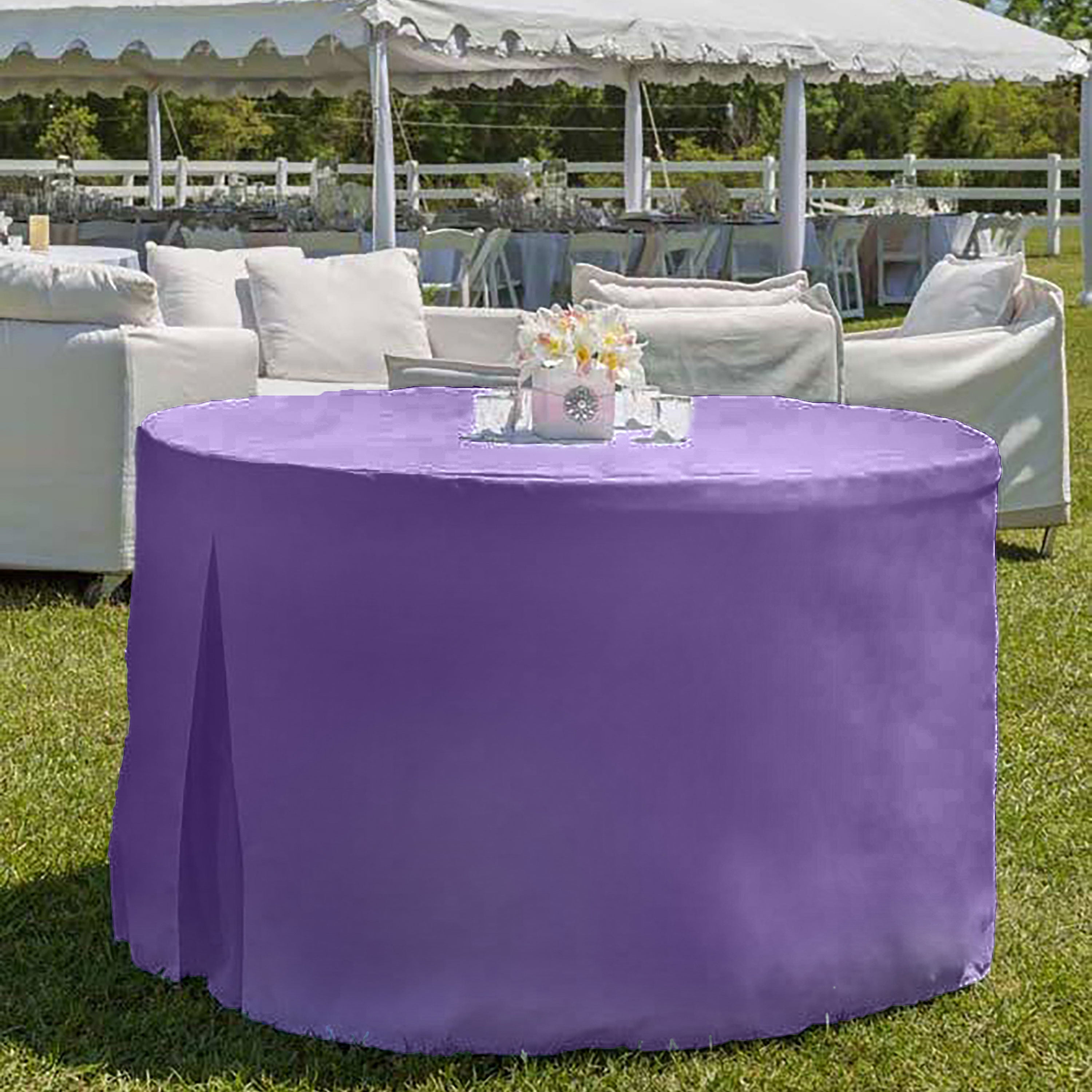 Round table covered with a purple tablecloth, set outdoors with white chairs and a decorative centerpiece.