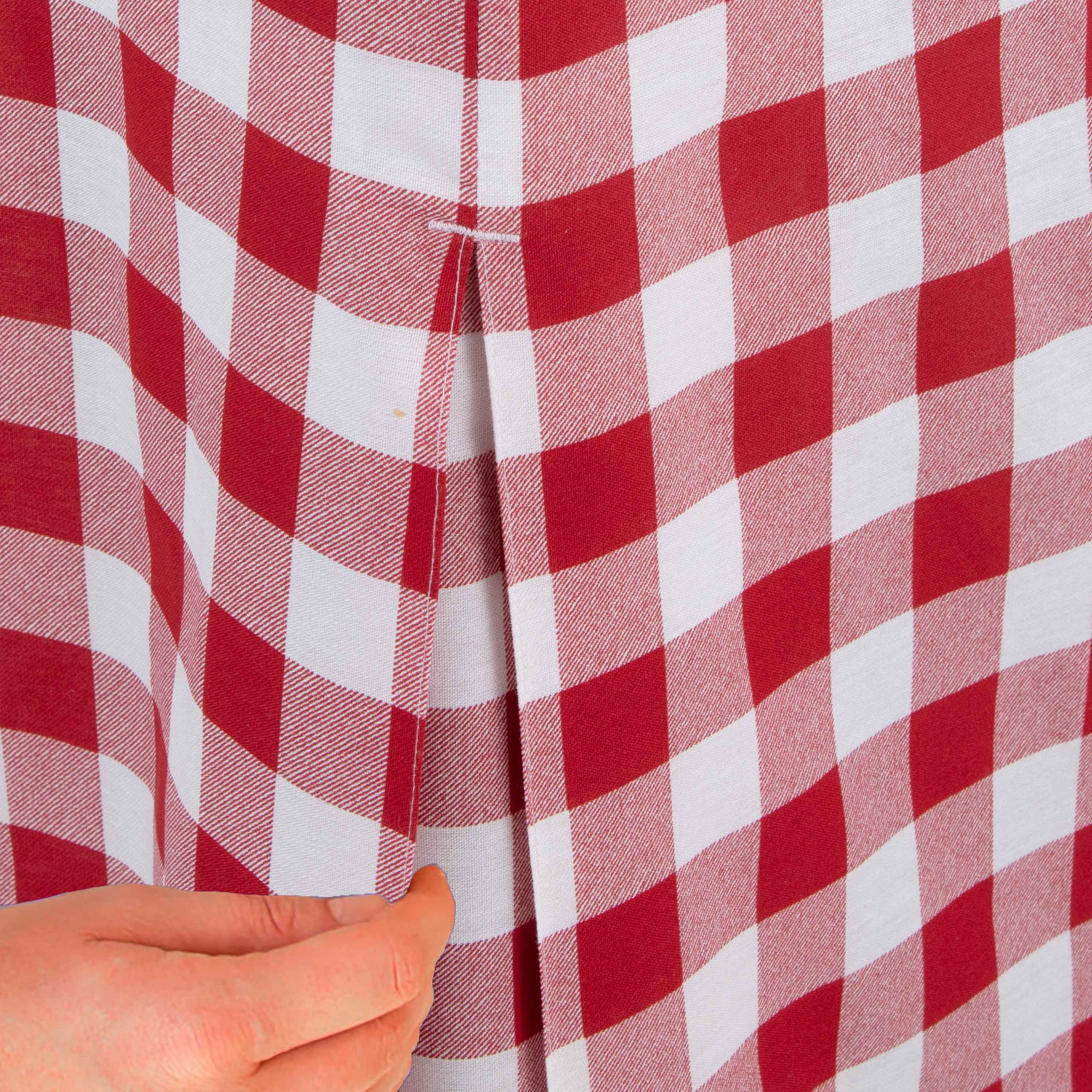 Red and white checkered table cover with a hand adjusting the fabric.