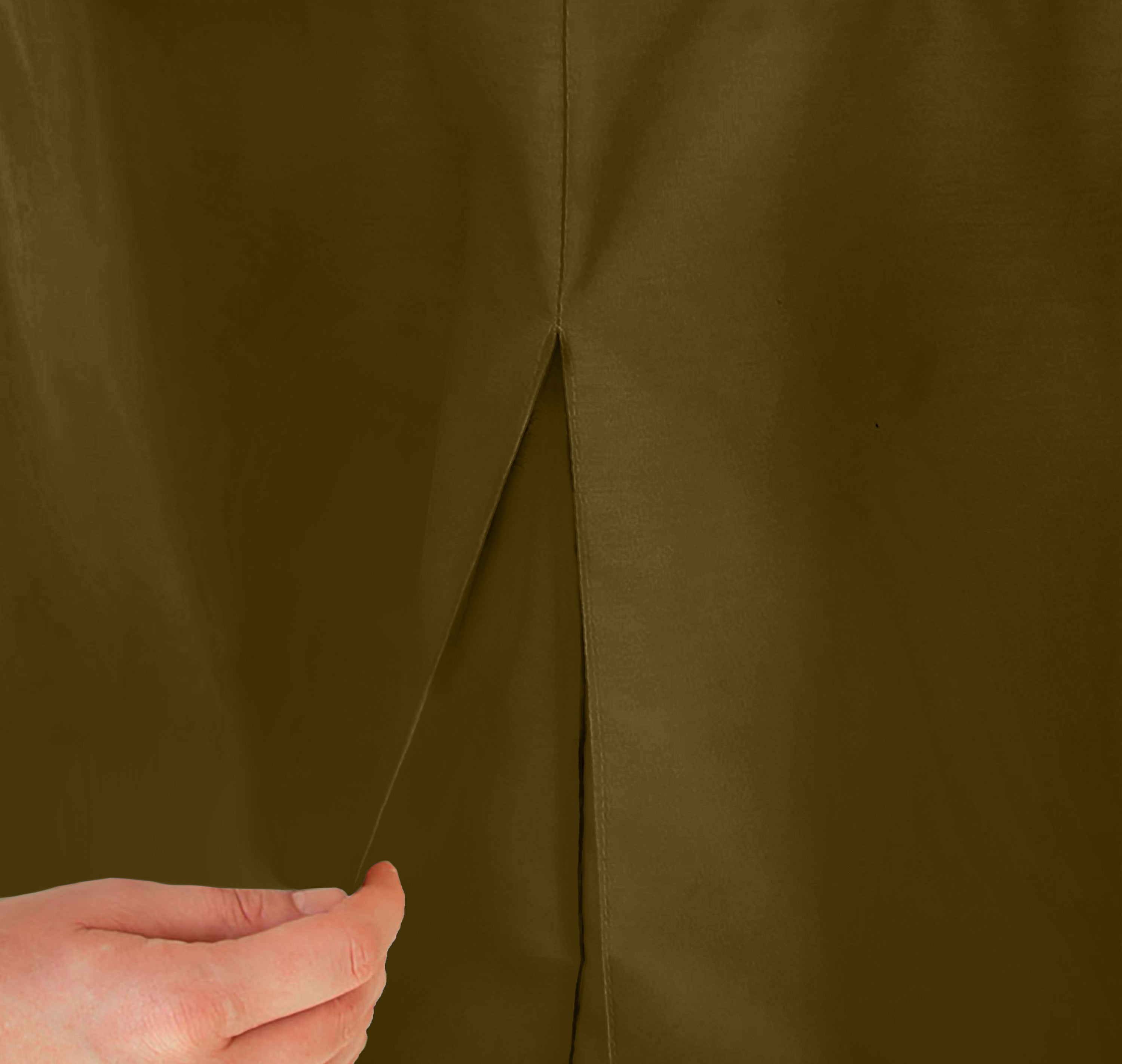 Close-up of a brown table cover with a pleat and a hand holding the fabric.