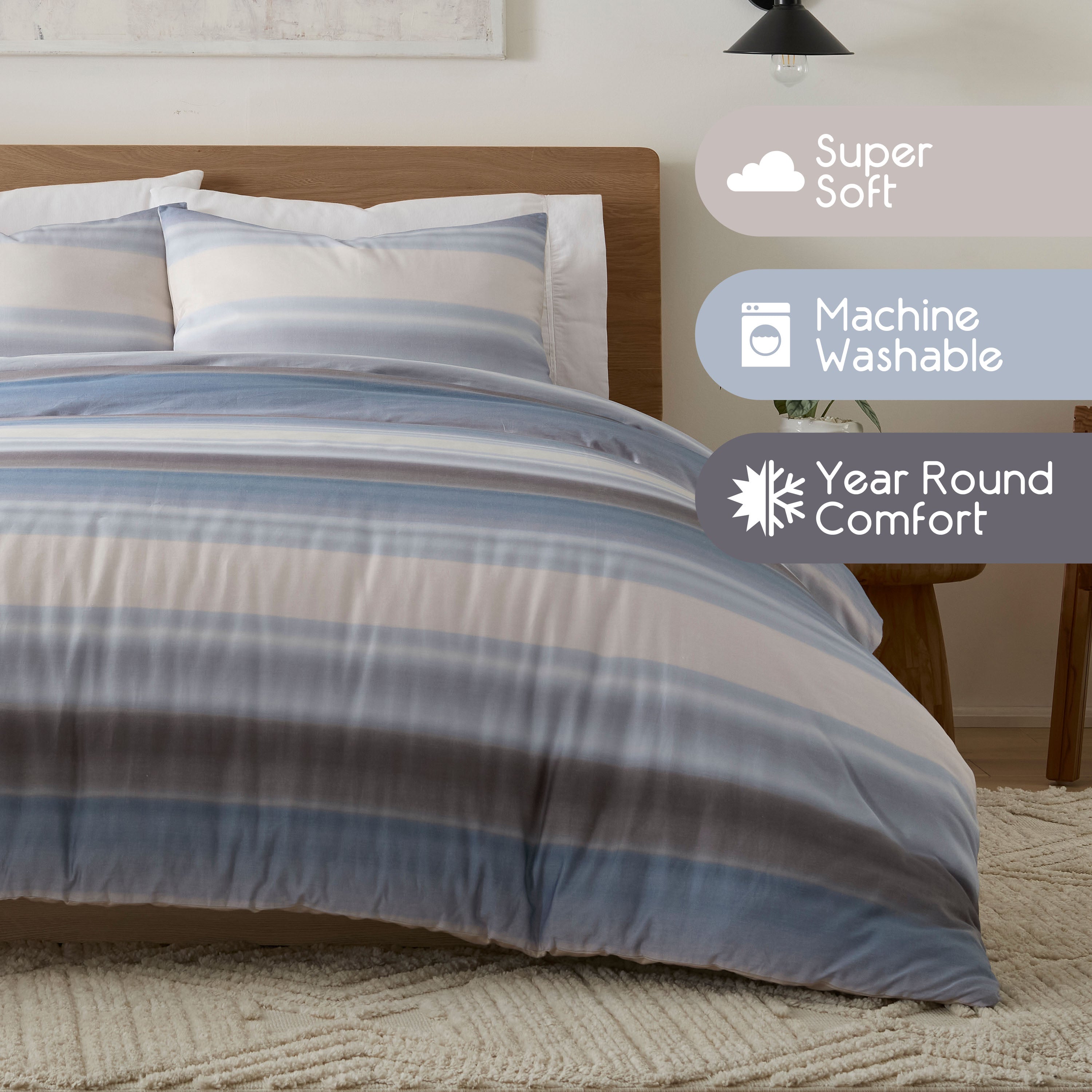 Comforter set featuring blue and gray stripes with two matching pillow shams on a wooden bed frame.