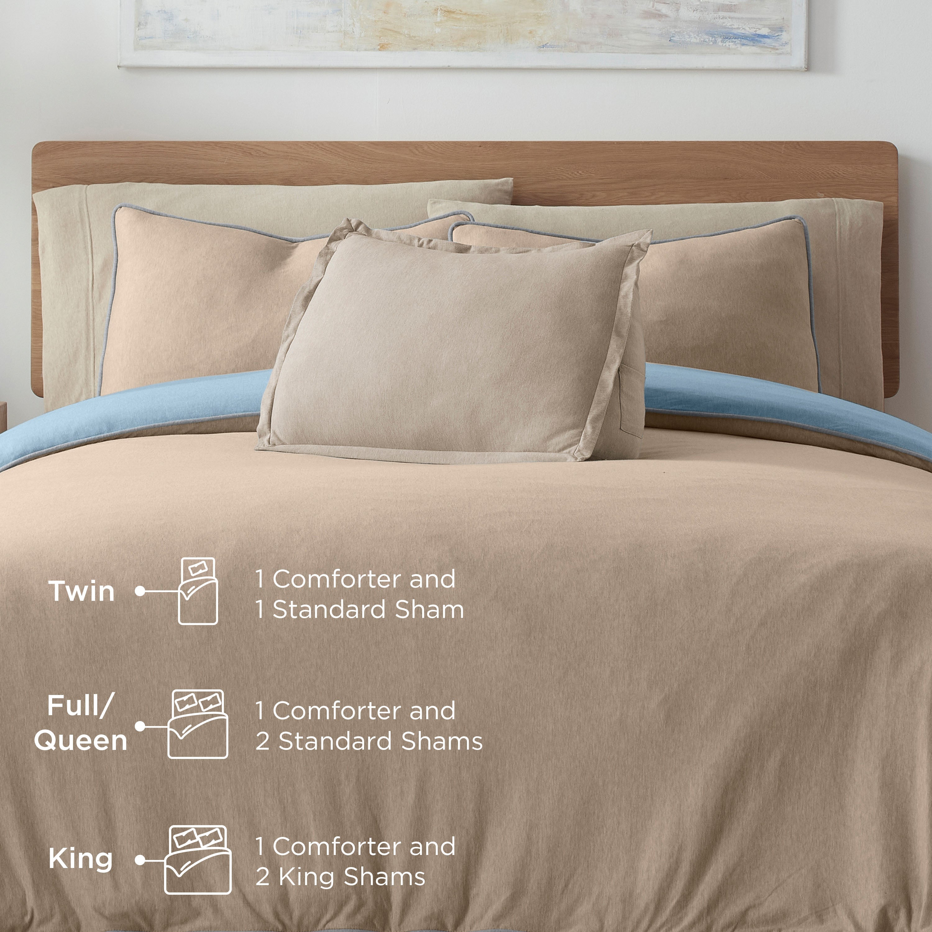 Comforter set displayed on a bed with various pillows and shams in neutral tones and a blue accent.