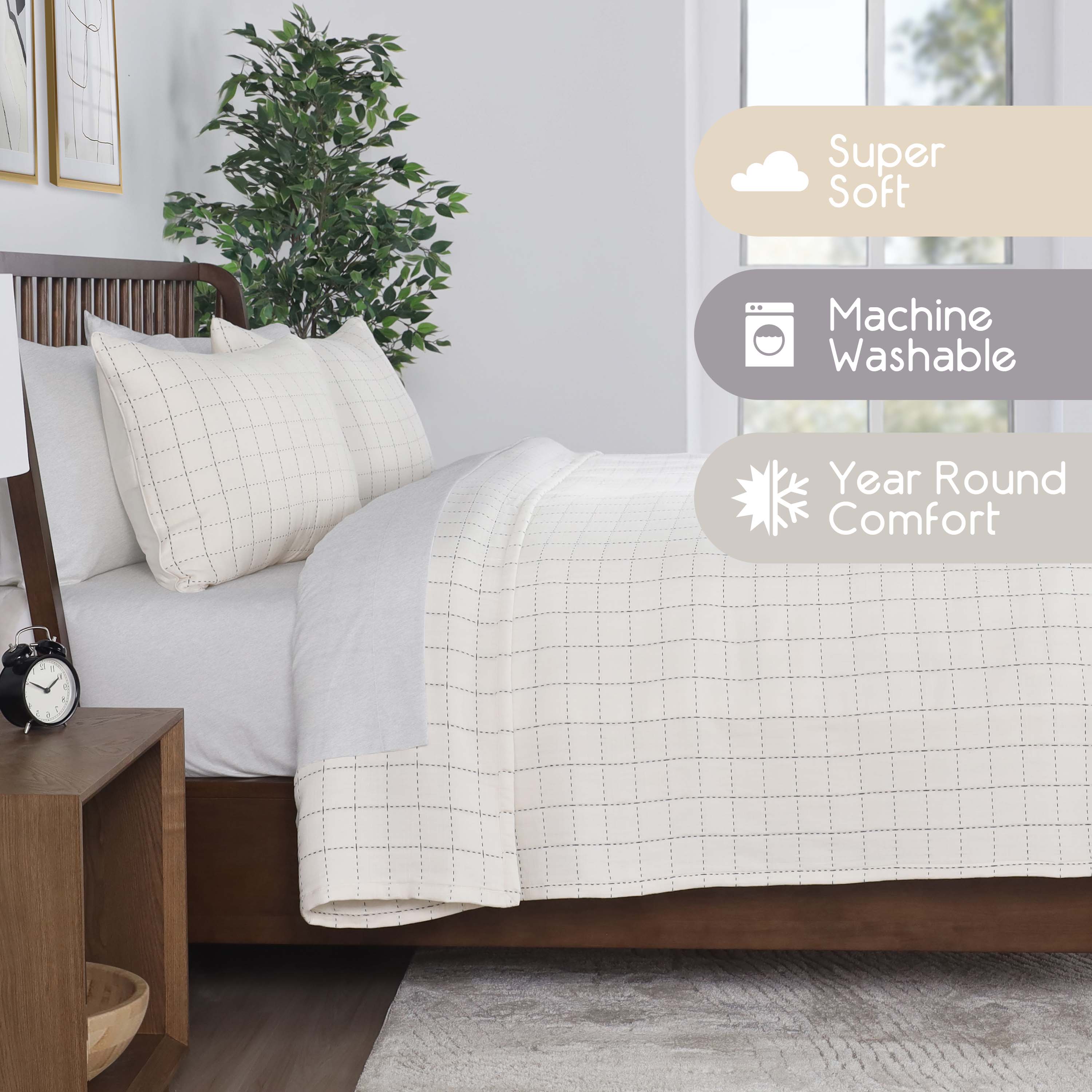 Coverlet set featuring a grid pattern, two pillows, and a light color scheme on a bed with a wooden frame.