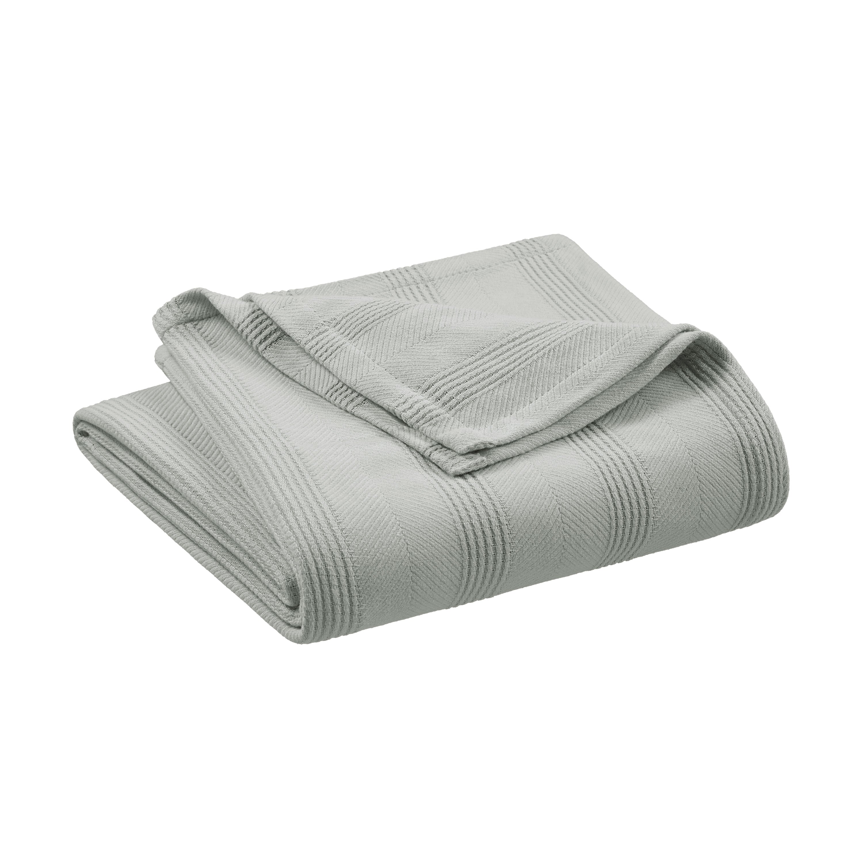 Light gray cotton blanket folded with a textured pattern and a smooth edge.