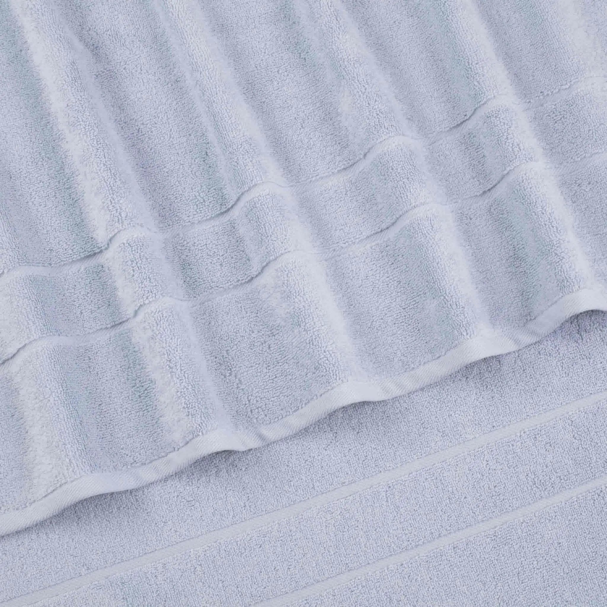A close-up of a blue terry cloth hand towel with a textured striped pattern and folded edges.