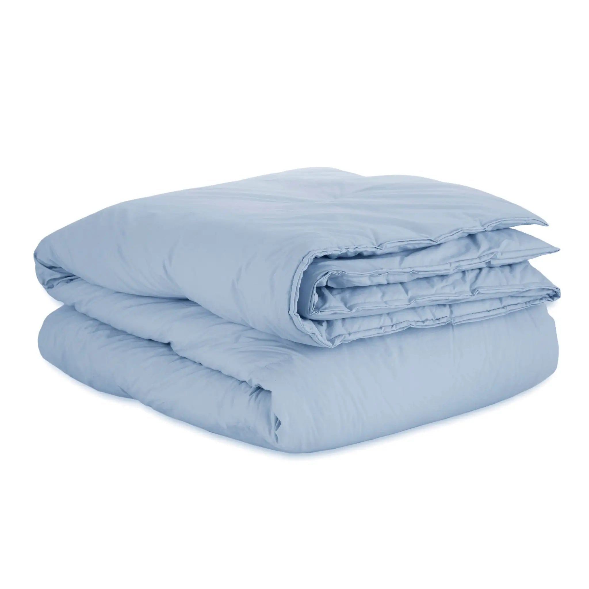 A folded light blue quilted comforter on a plain white background.