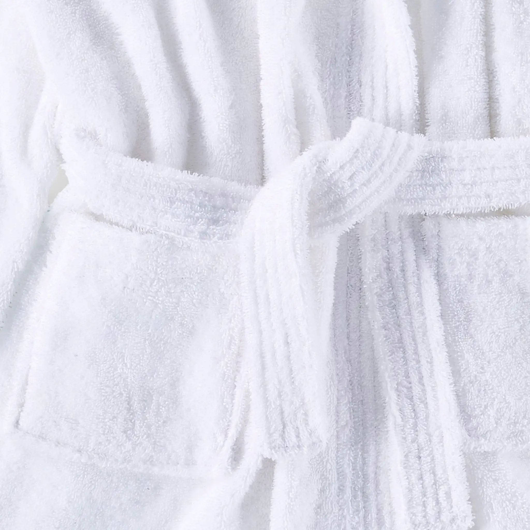 A close-up of a white terry cloth bathrobe with a matching tie belt, showing the soft textured fabric and stitched pocket details.