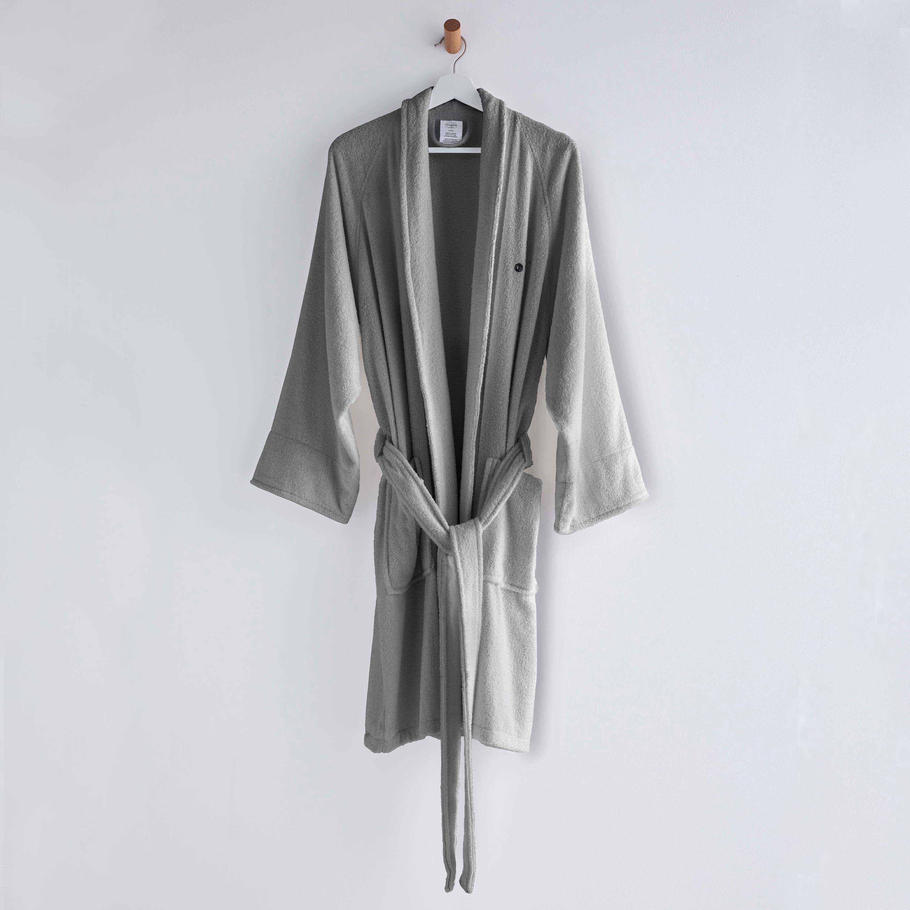Gray terry bath robe with long sleeves, a belt, and two front pockets, hanging on a wall hook.
