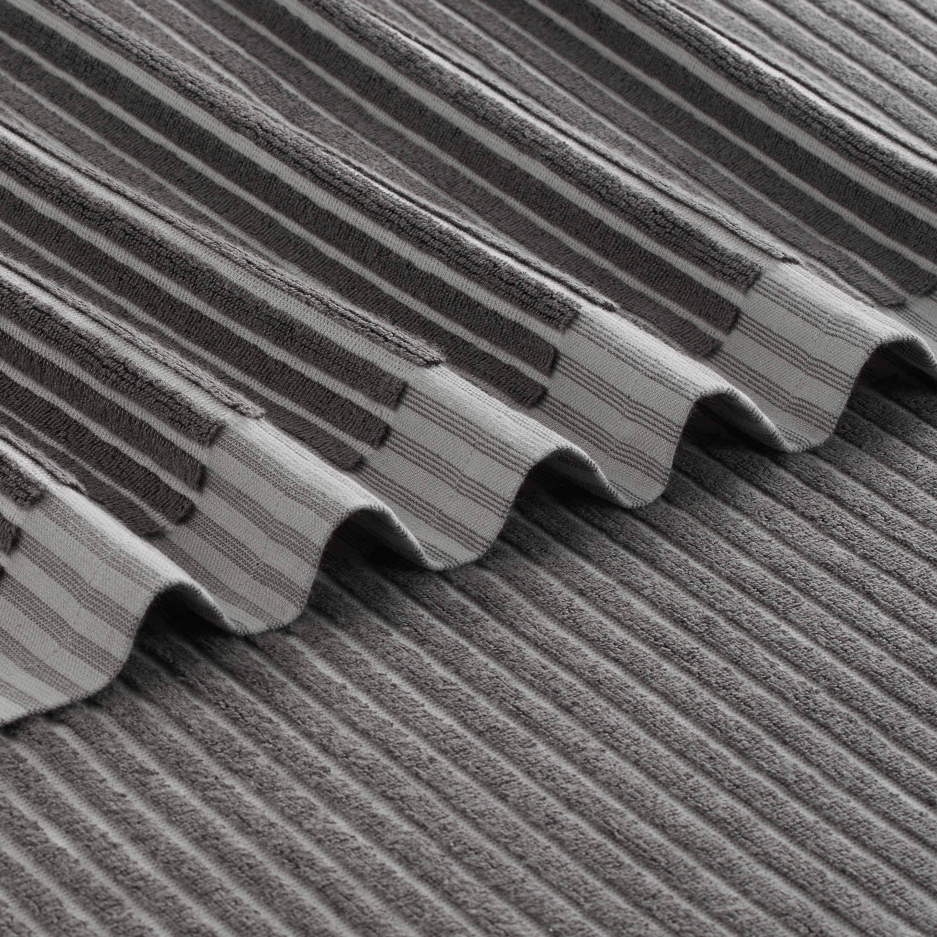 Gray towels with a sculpted stripe pattern, featuring alternating textured and smooth sections.
