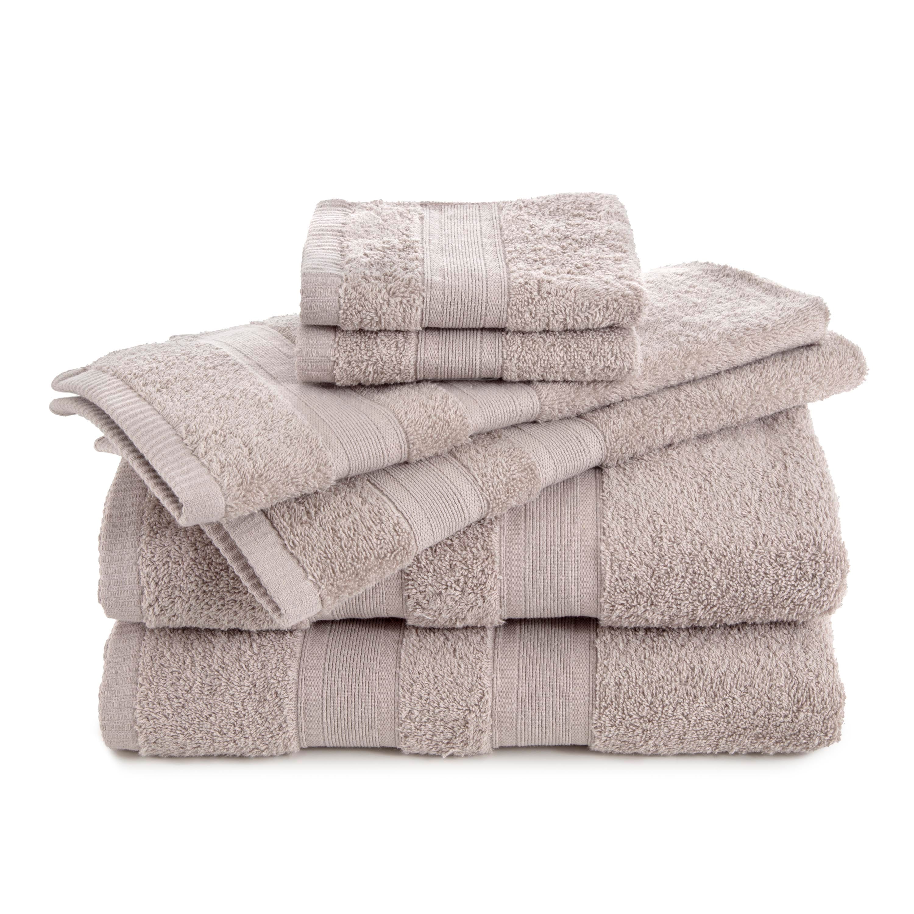 Six solid beige towels stacked, including two bath towels, two hand towels, and two washcloths.