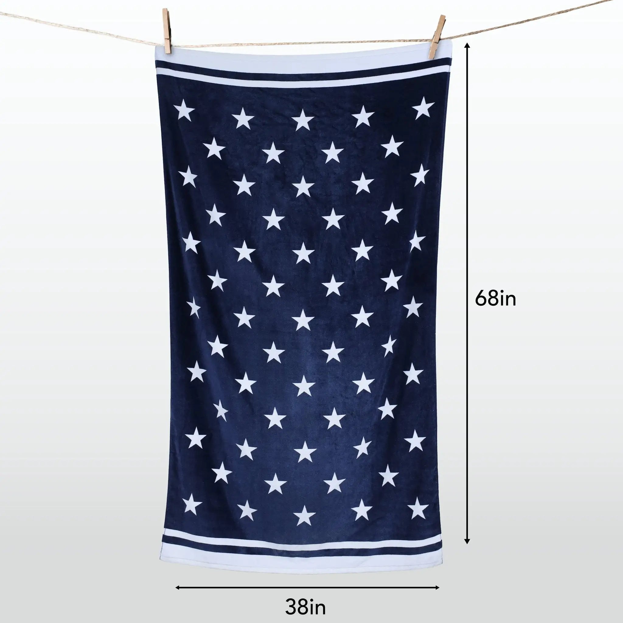 A navy blue towel with a white star pattern and white striped borders, hanging from a clothesline with dimension markers showing 38 inches by 68 inches.