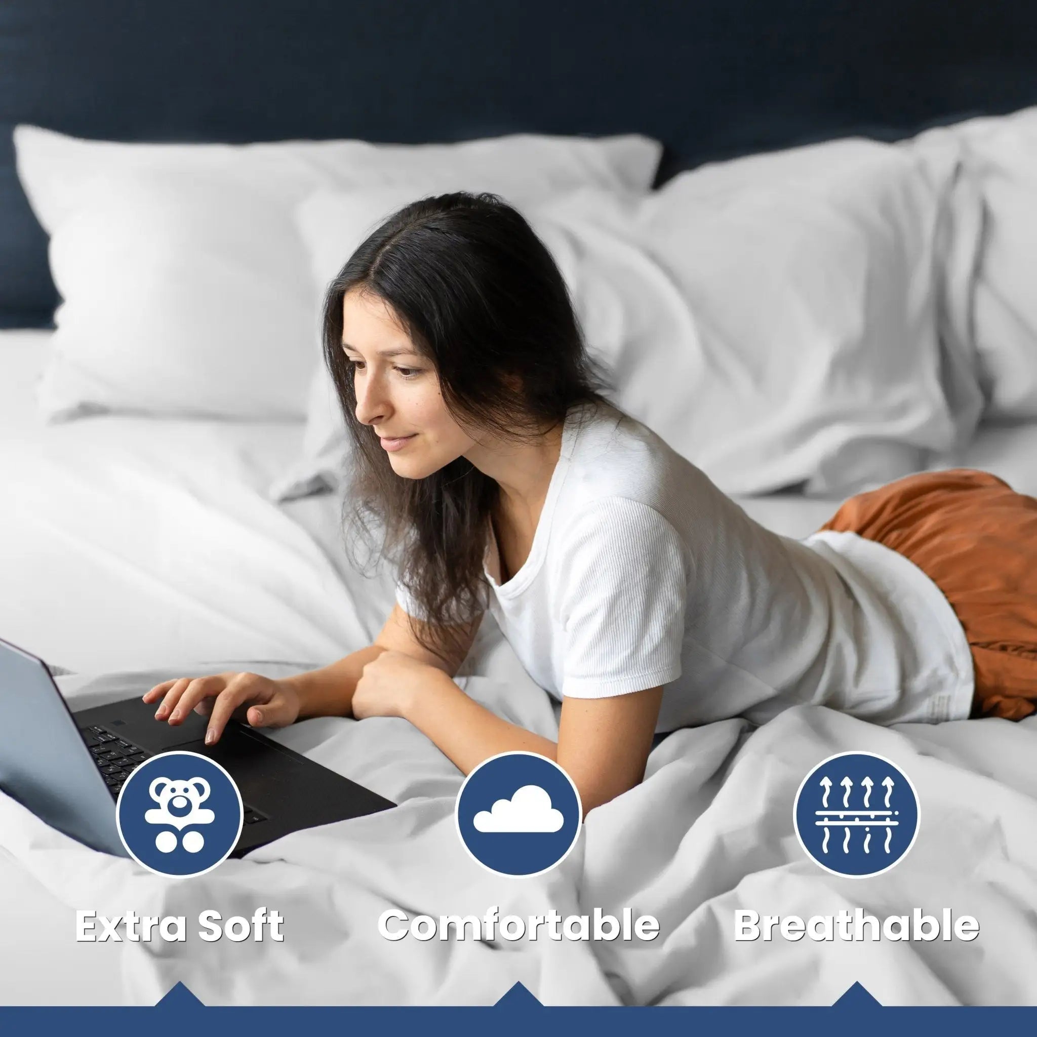 A woman lies on a bed, the bed has white sheets and pillows.