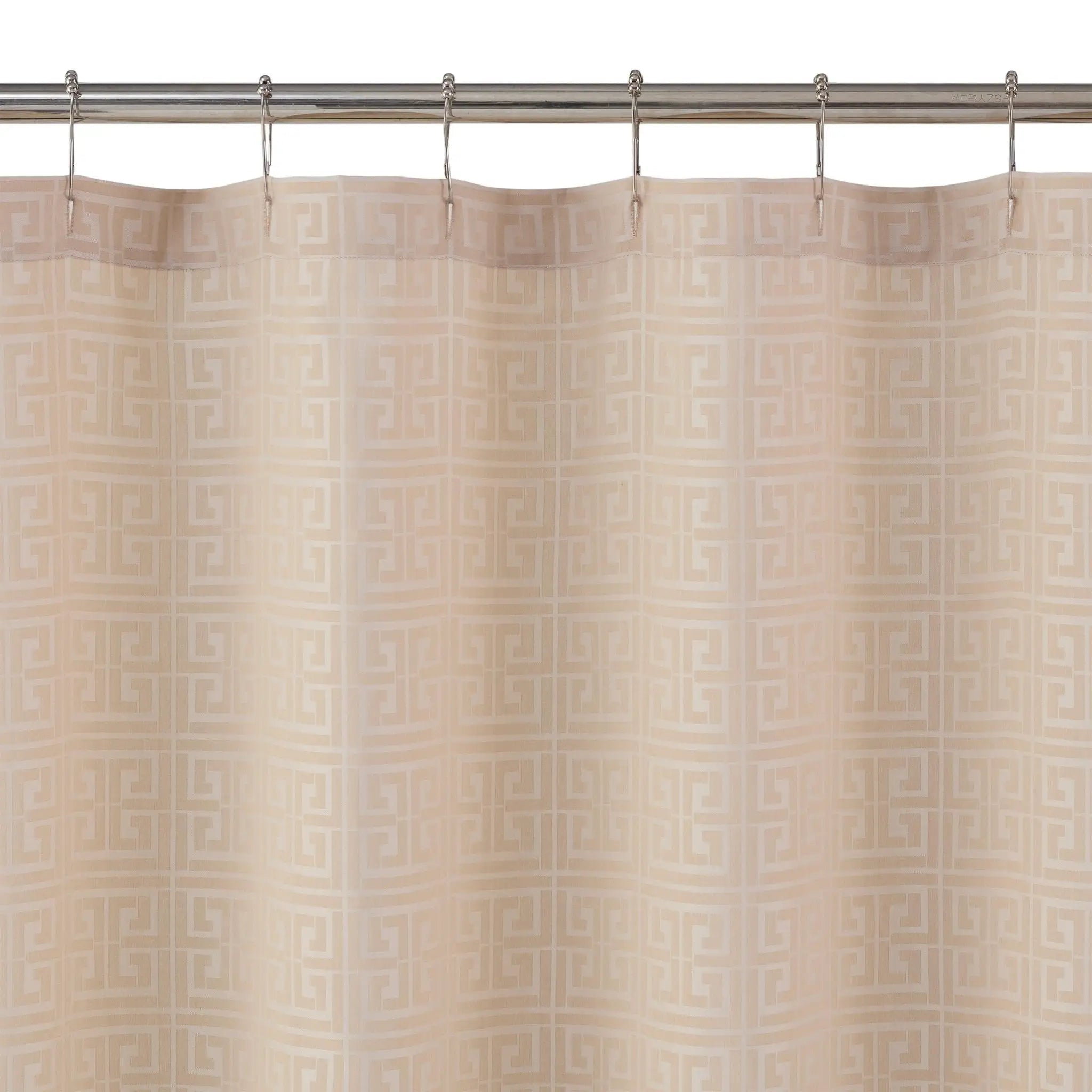 Beige shower curtain with a repeating Greek key pattern, hanging from a silver metal rod with hooks against a white background.