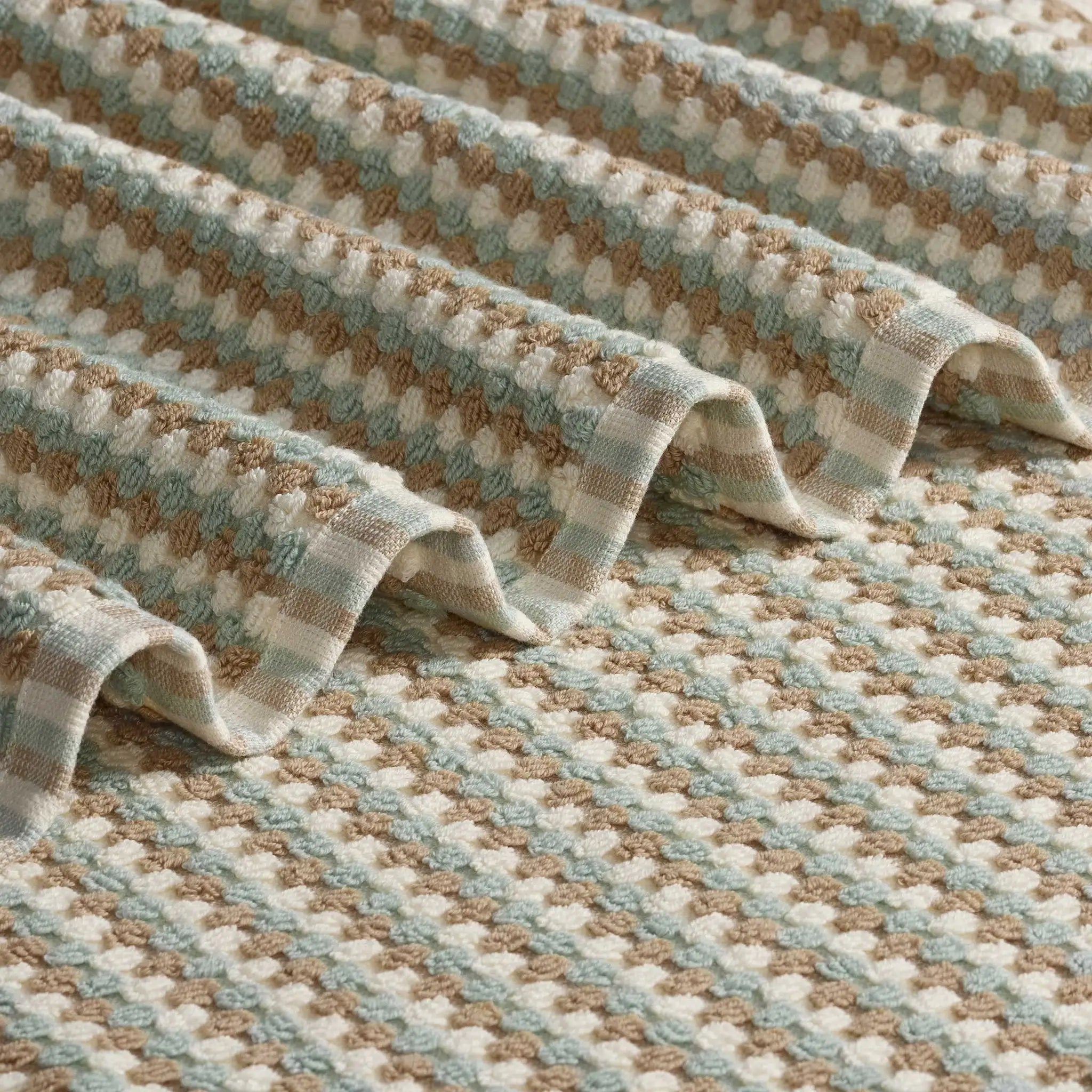 A close-up of a pebble bath towel with a repeating geometric pattern.