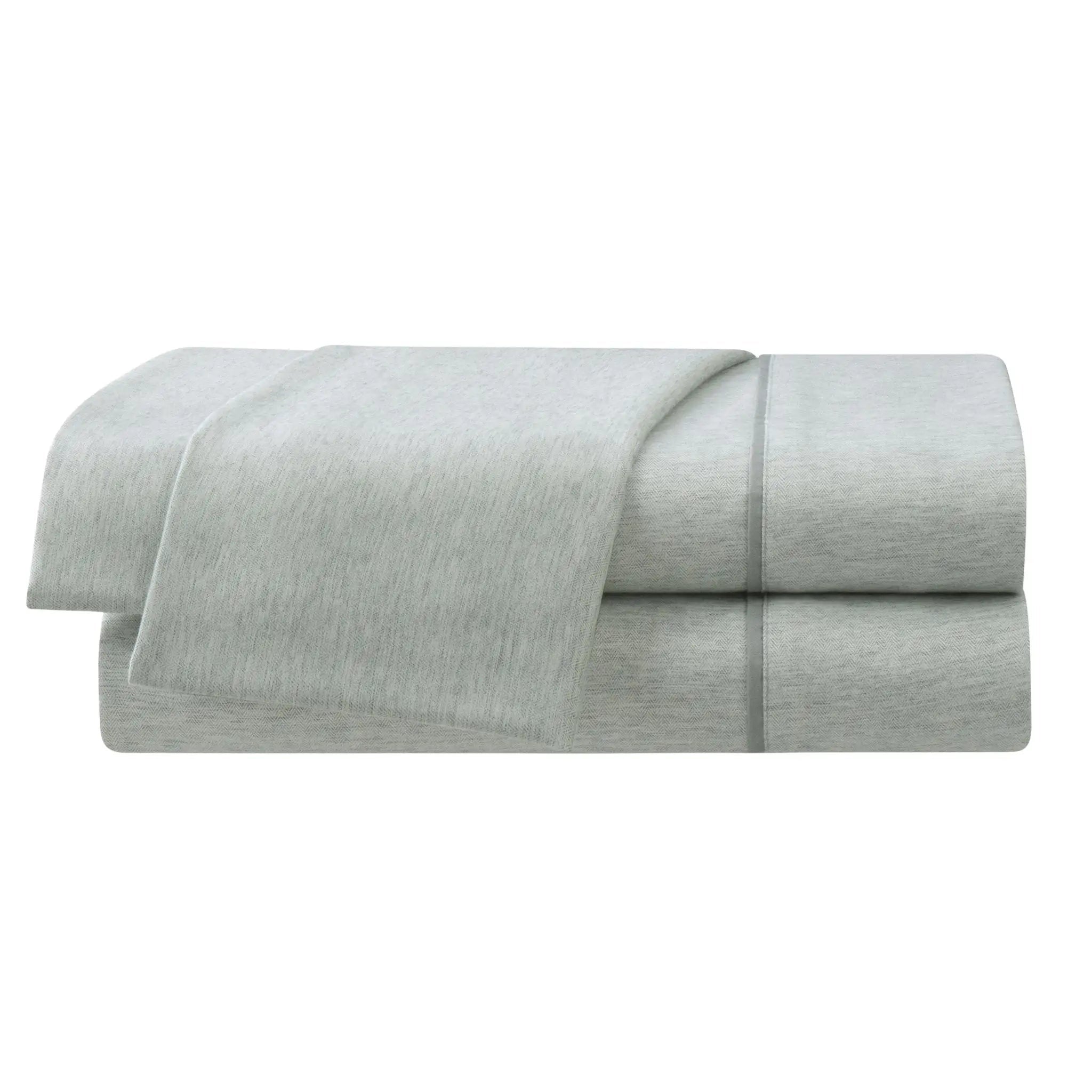 Folded light gray bed sheets on a white background