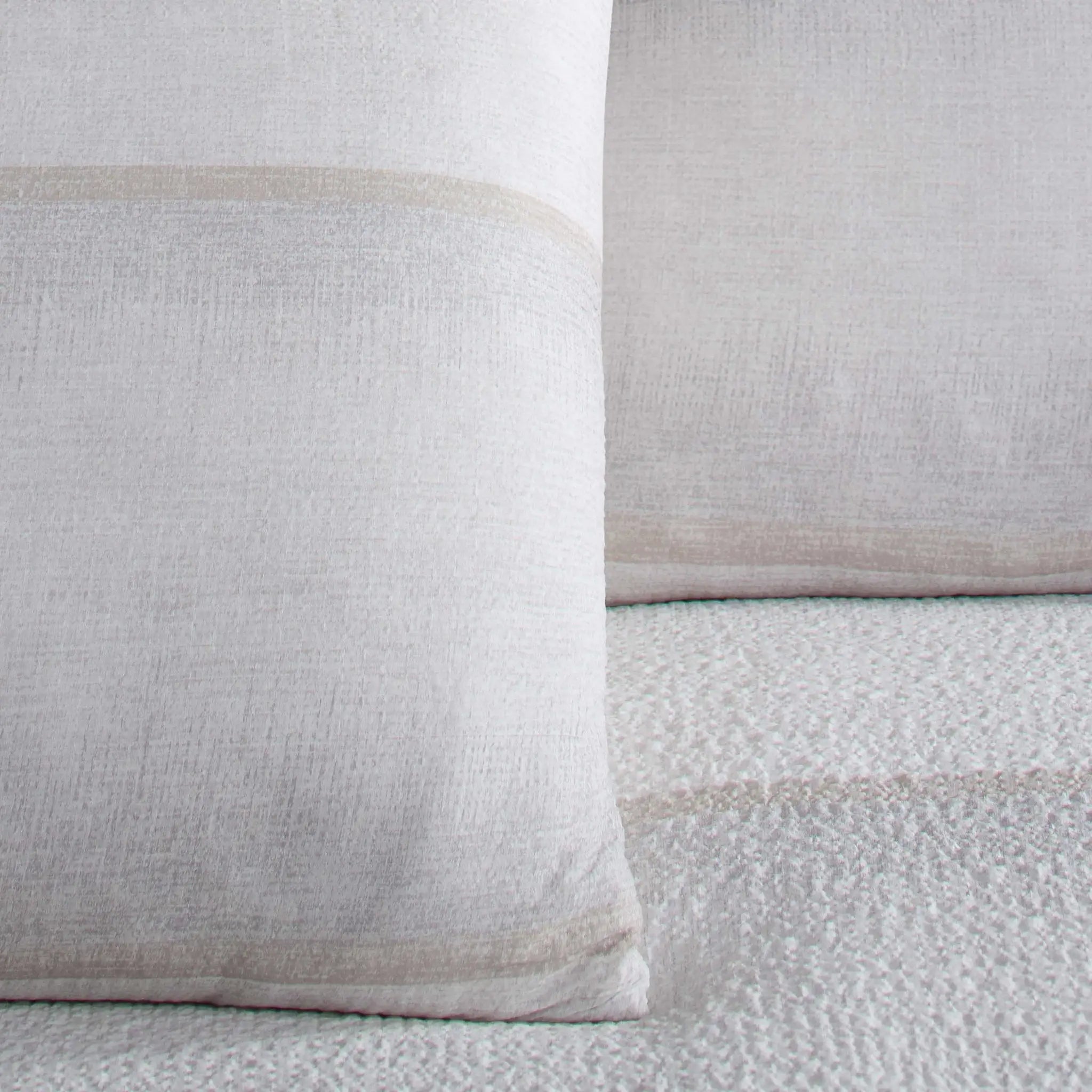 Close-up of two textured pillow shams on a matching fabric background