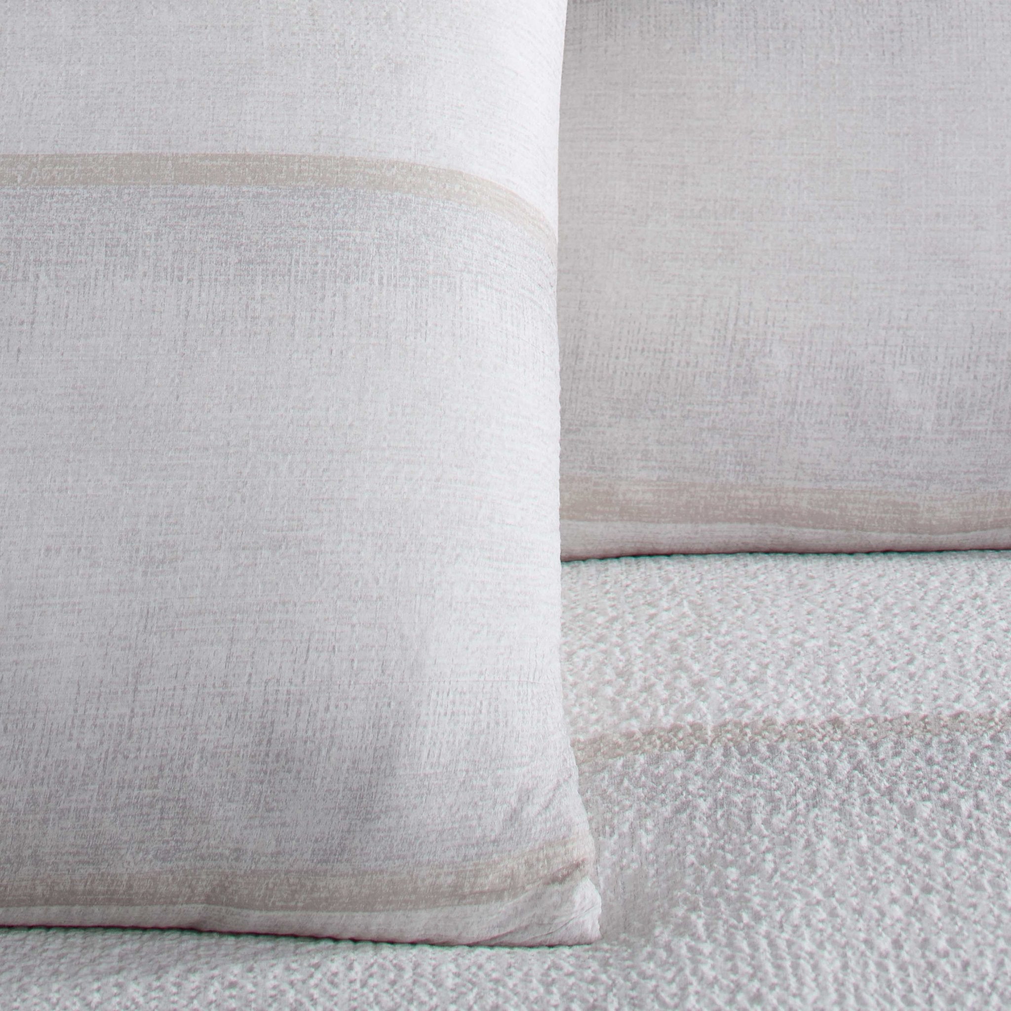 Close-up of two textured pillow shams on a matching fabric background