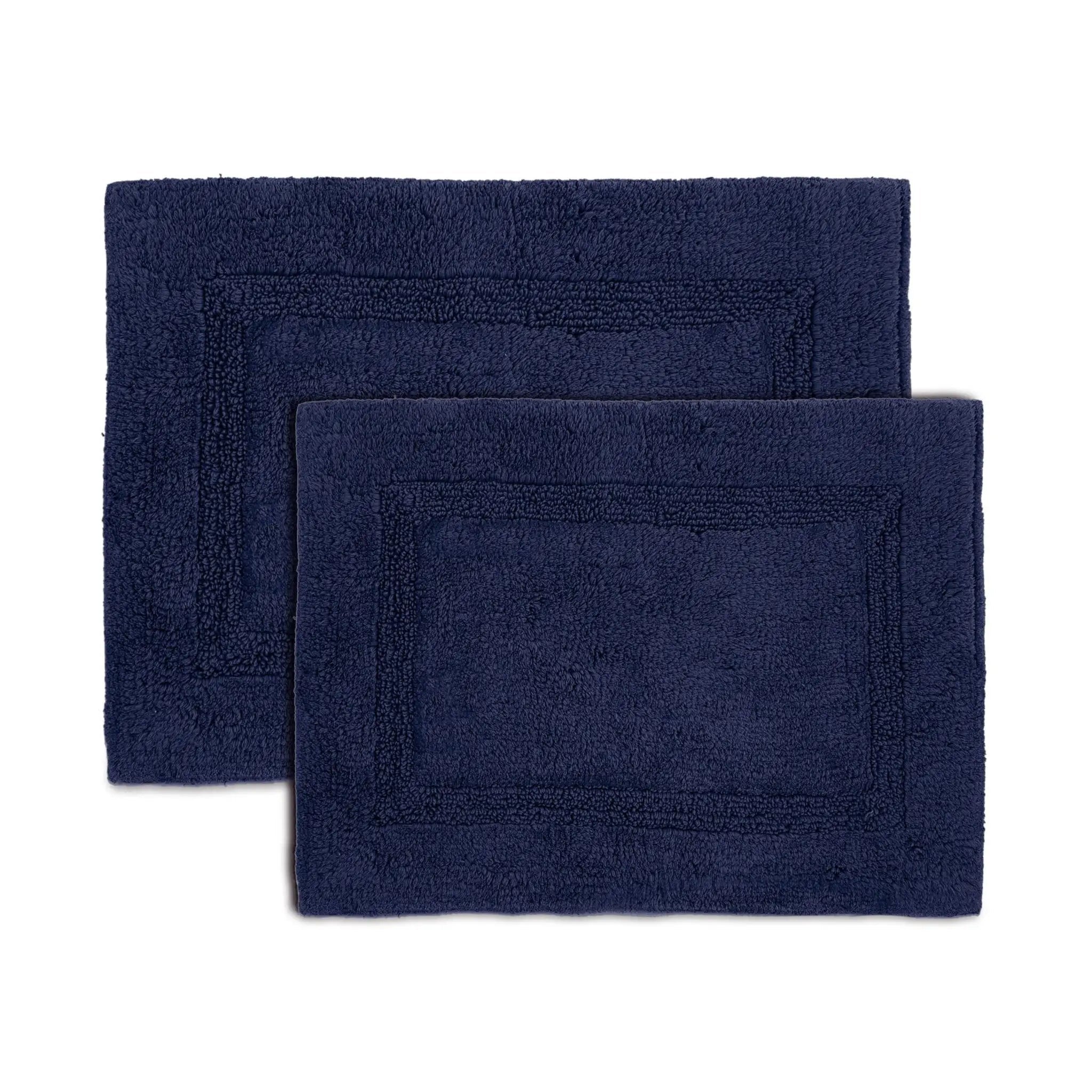 Two estate blue bath rugs on a white background