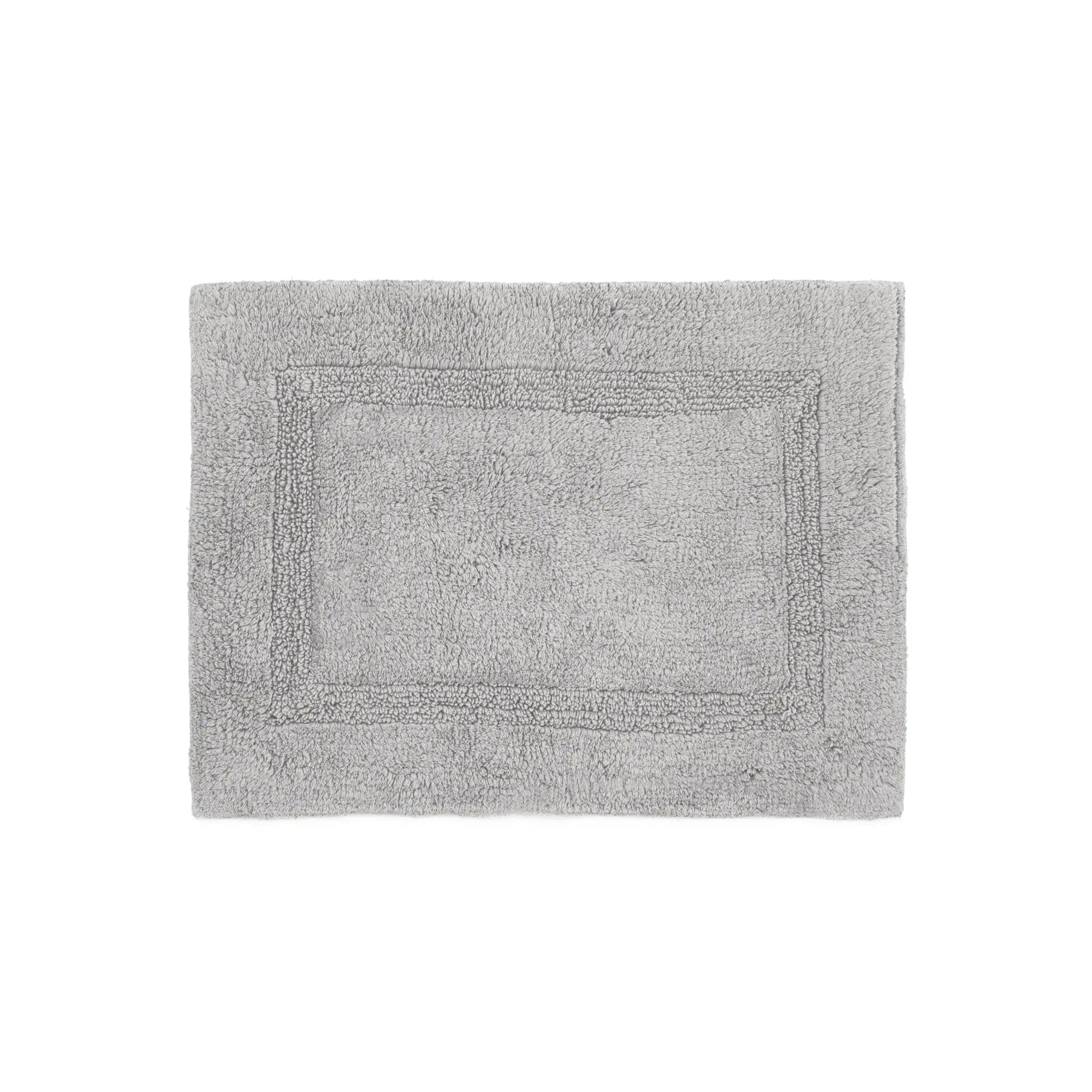 Gray bath rug with a textured border on a white background