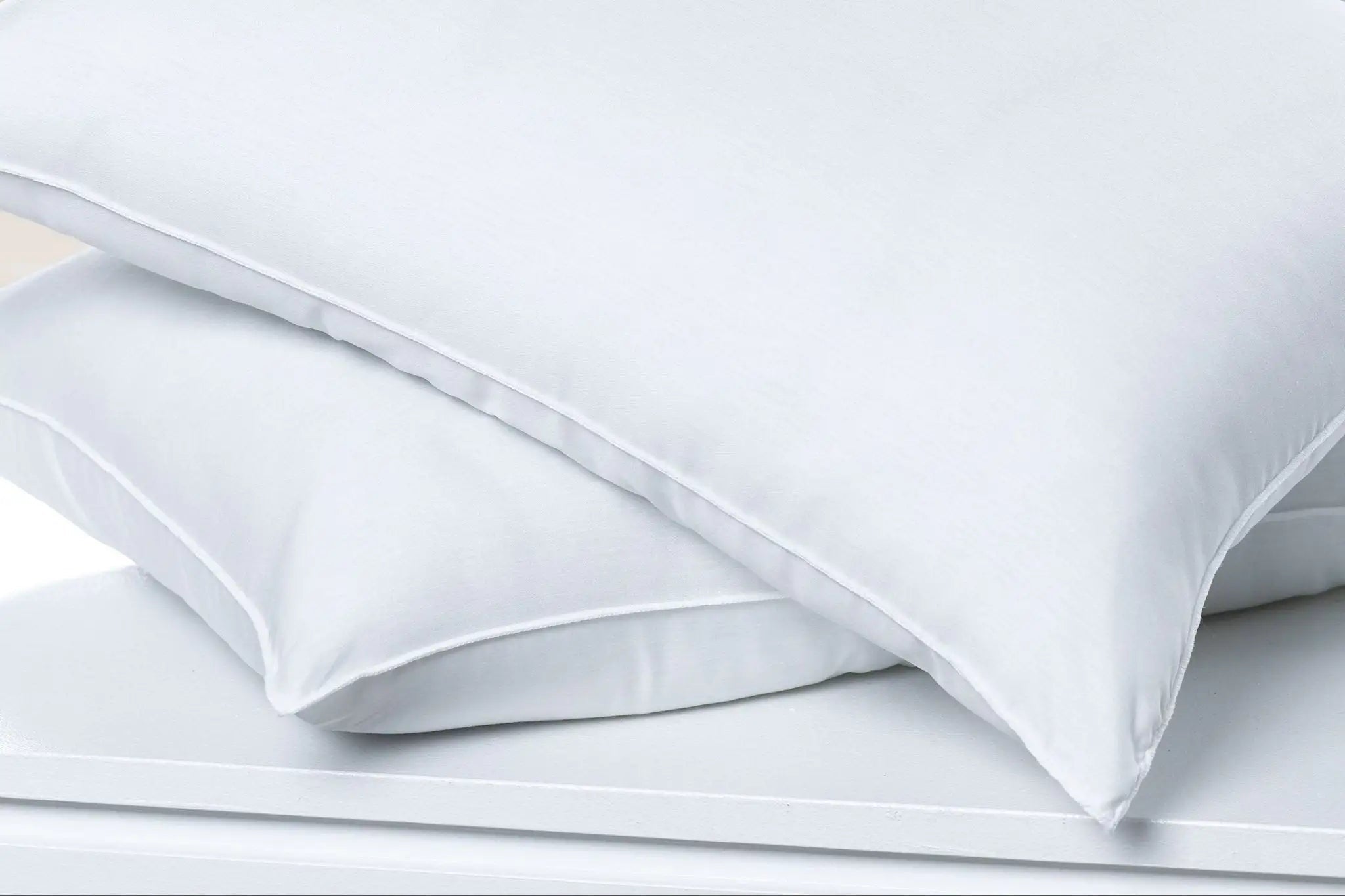 Stack of white pillows on a light gray background