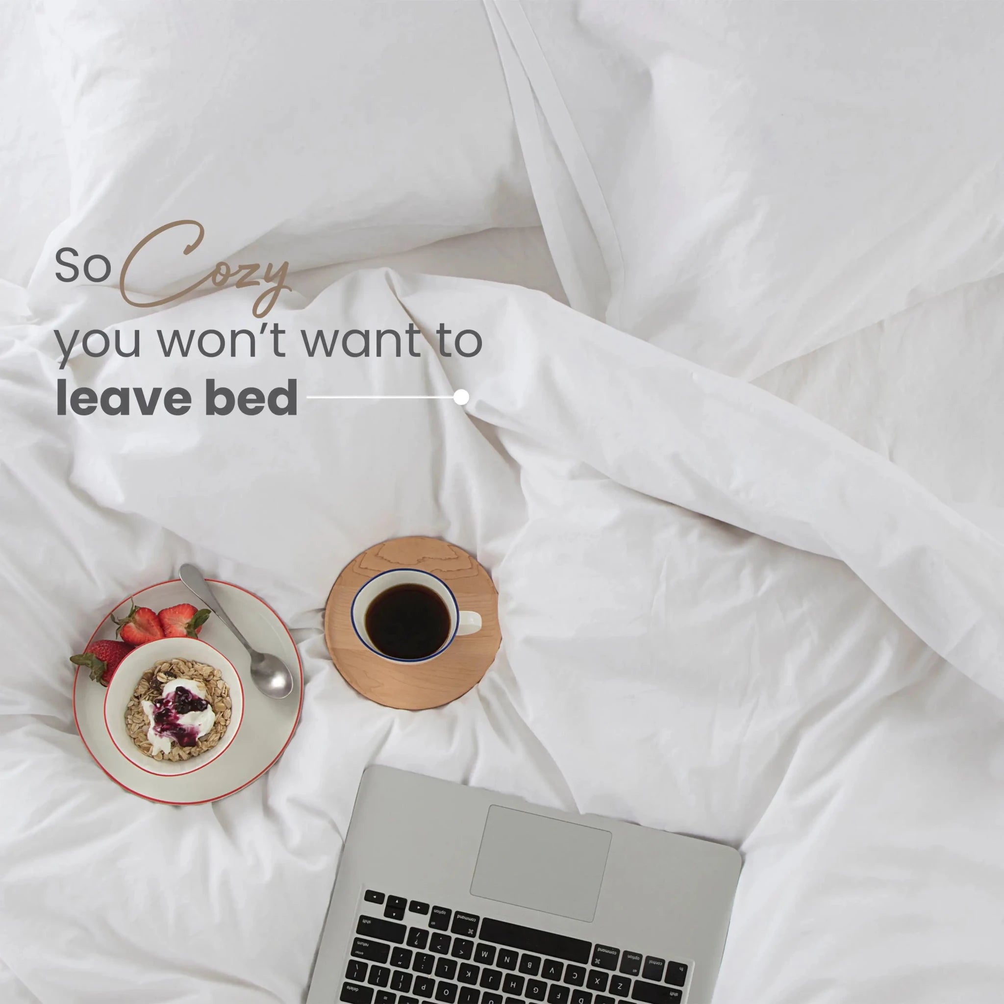 Cozy bedroom scene with laptop, coffee, and plate of food on white comforter set.