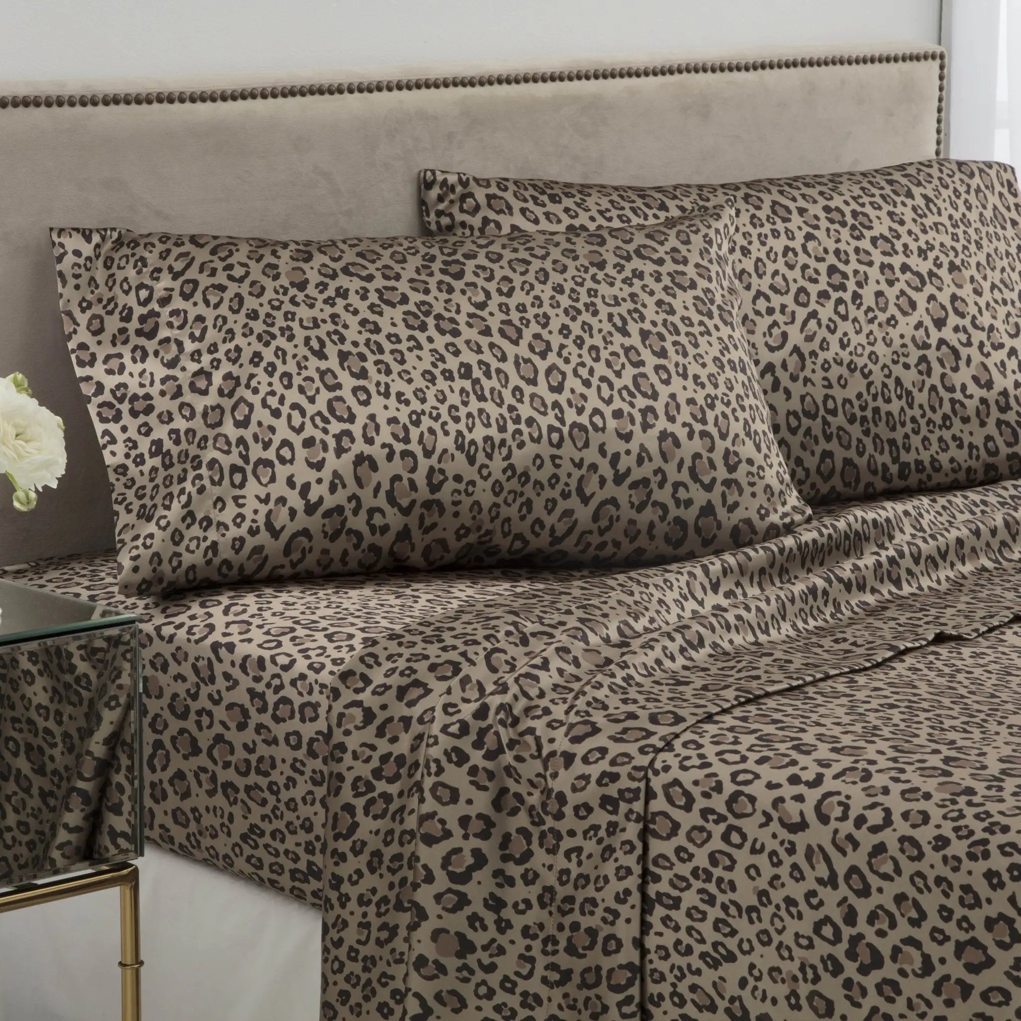 Leopard print bedding set on a bed with a white wall background