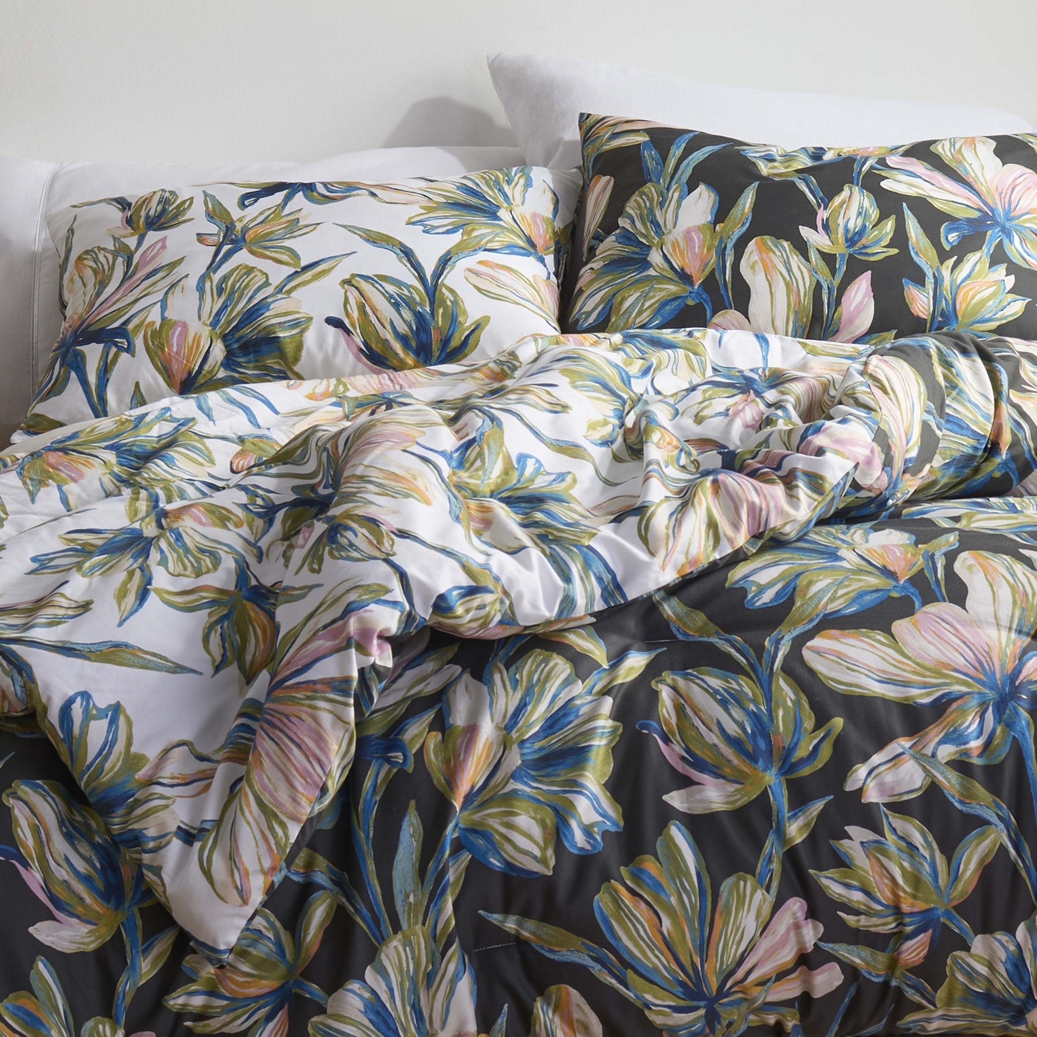 Floral comforter set on a bed with a white wall background