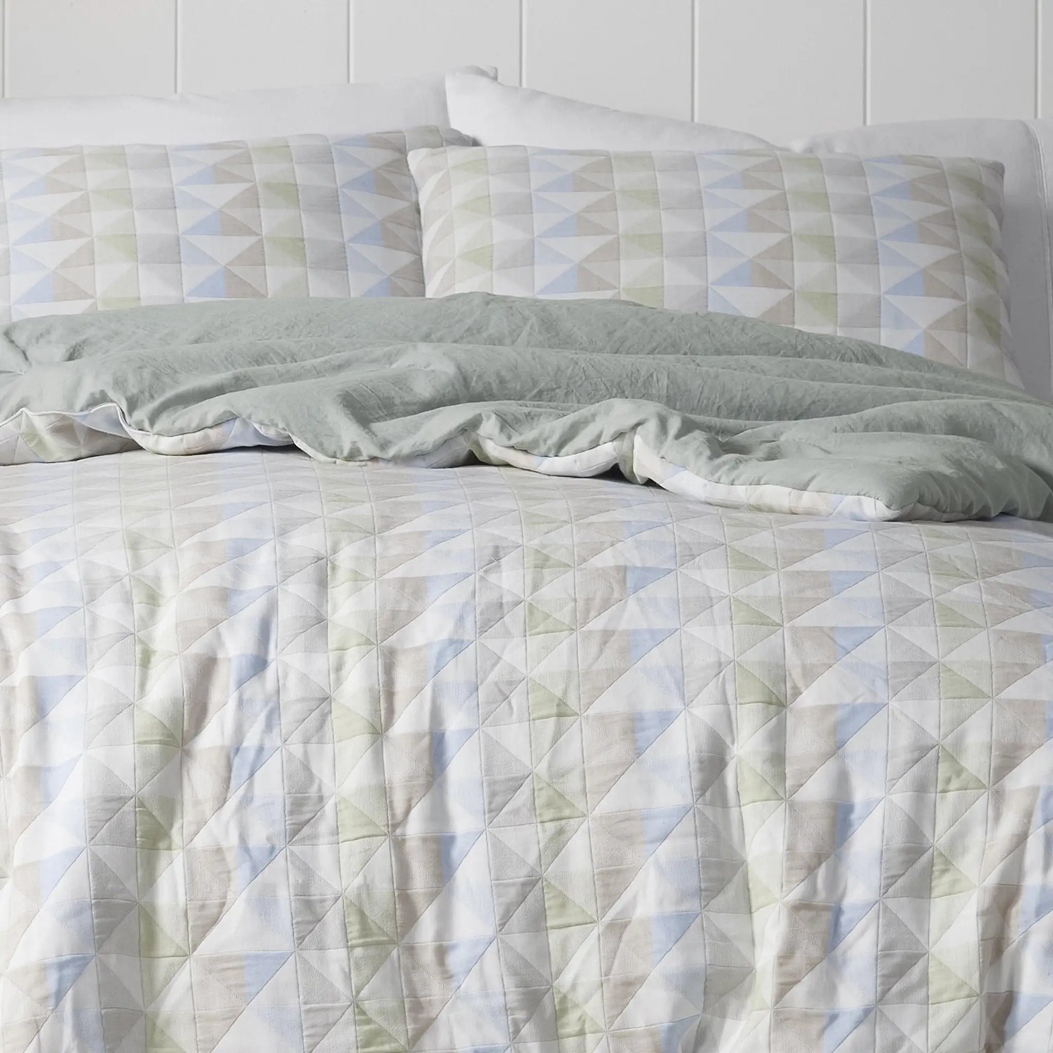 Comforter with geometric pattern on a bed.
