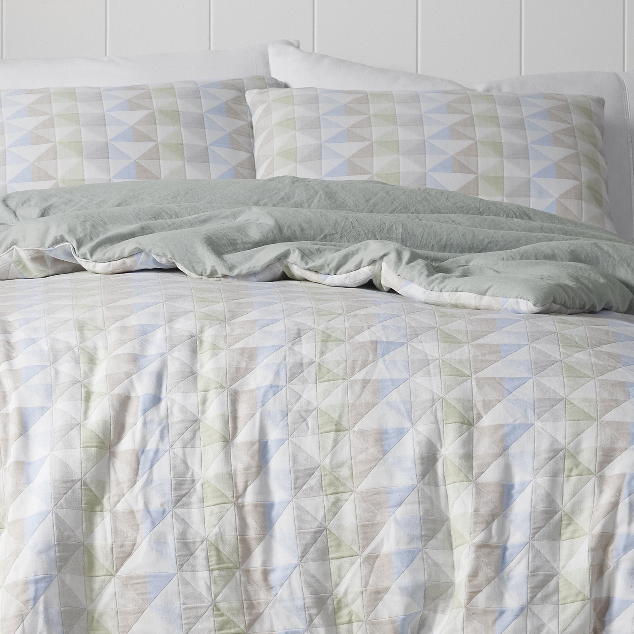Quilted comforter set with geometric pattern on a bed.