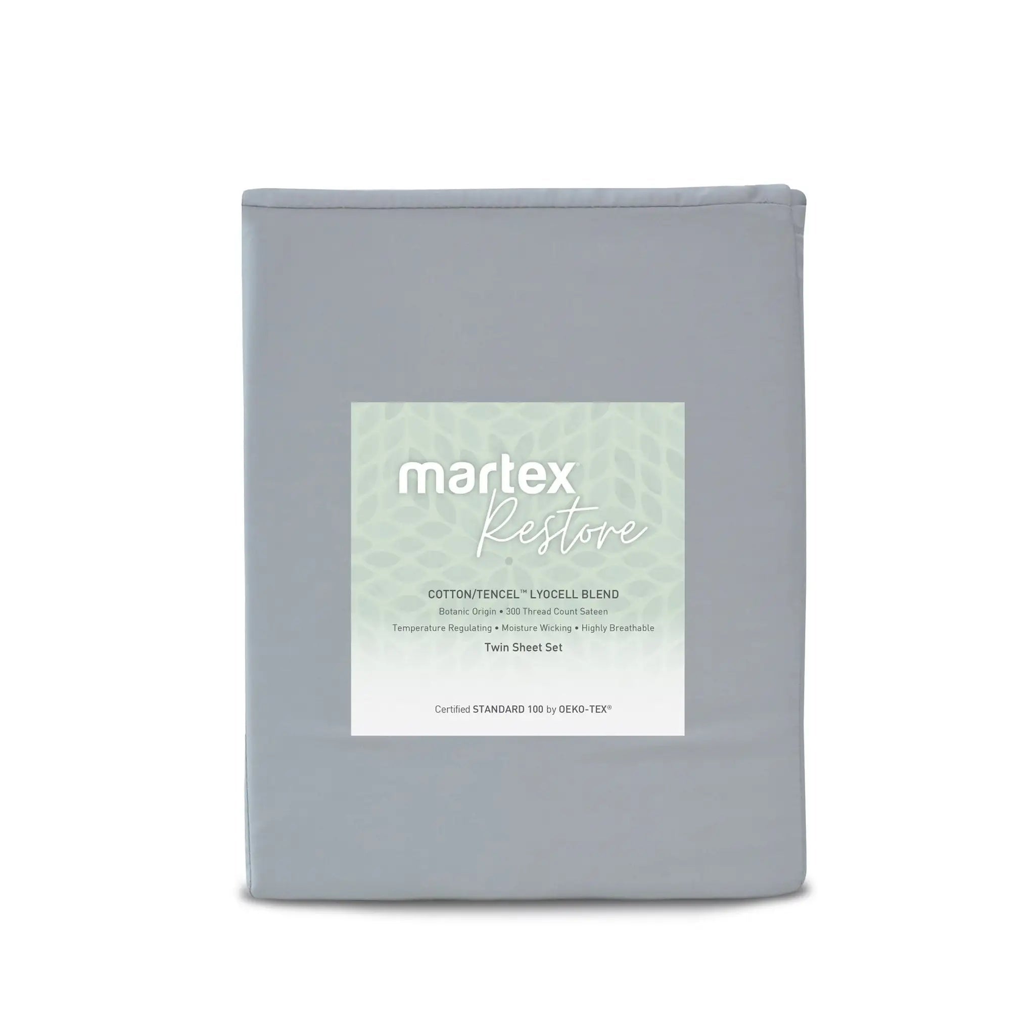 A folded gray bedding sheet set in a matte fabric, featuring a white paper label on the front with the brand name 'martex Restore' and product details for a cotton-tenniscell 4-piece blend.