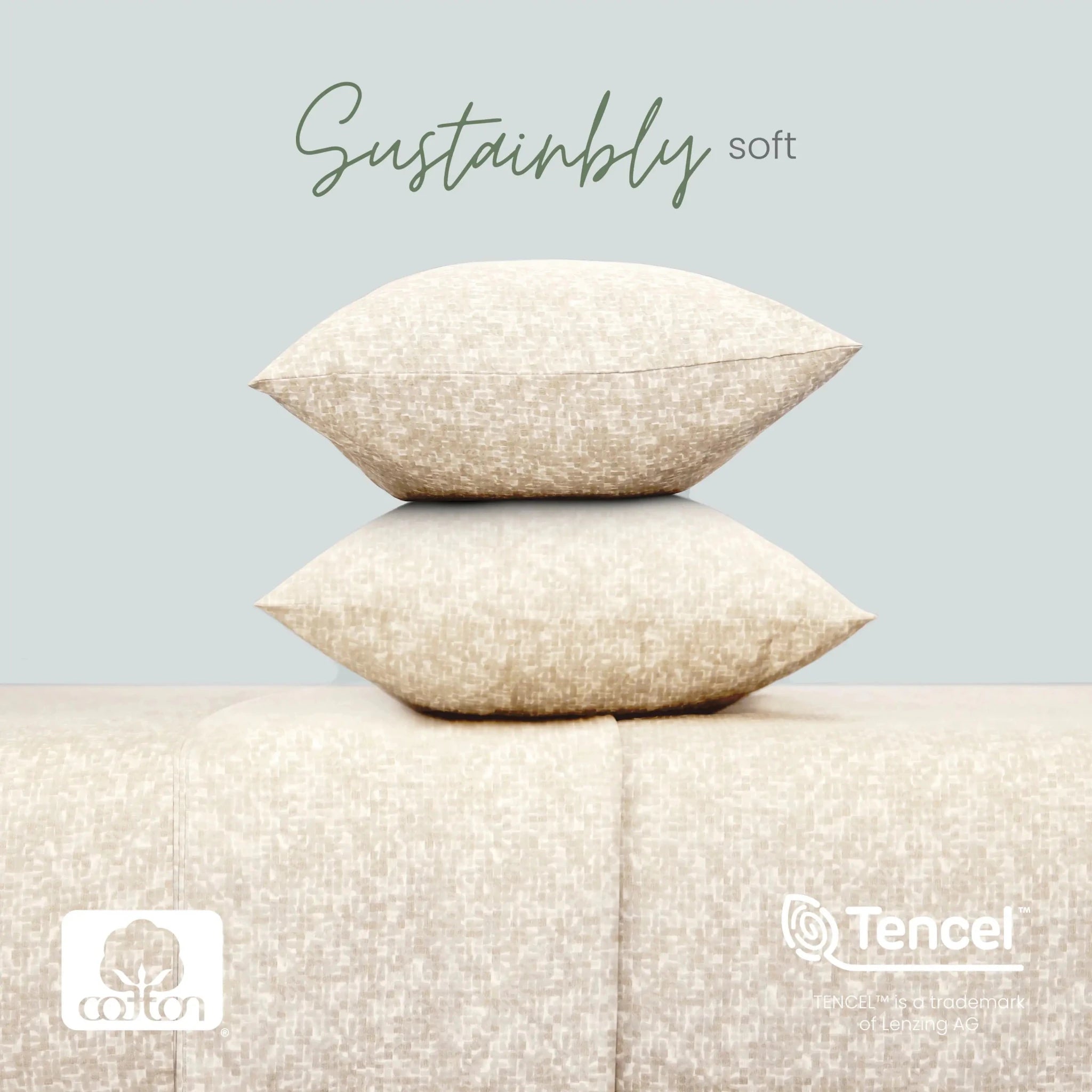 Two stacked beige textured throw pillows on a matching upholstered surface against a pale blue-gray background, with the words 'Sustainably soft' above and cotton and TENCEL logos at the bottom.