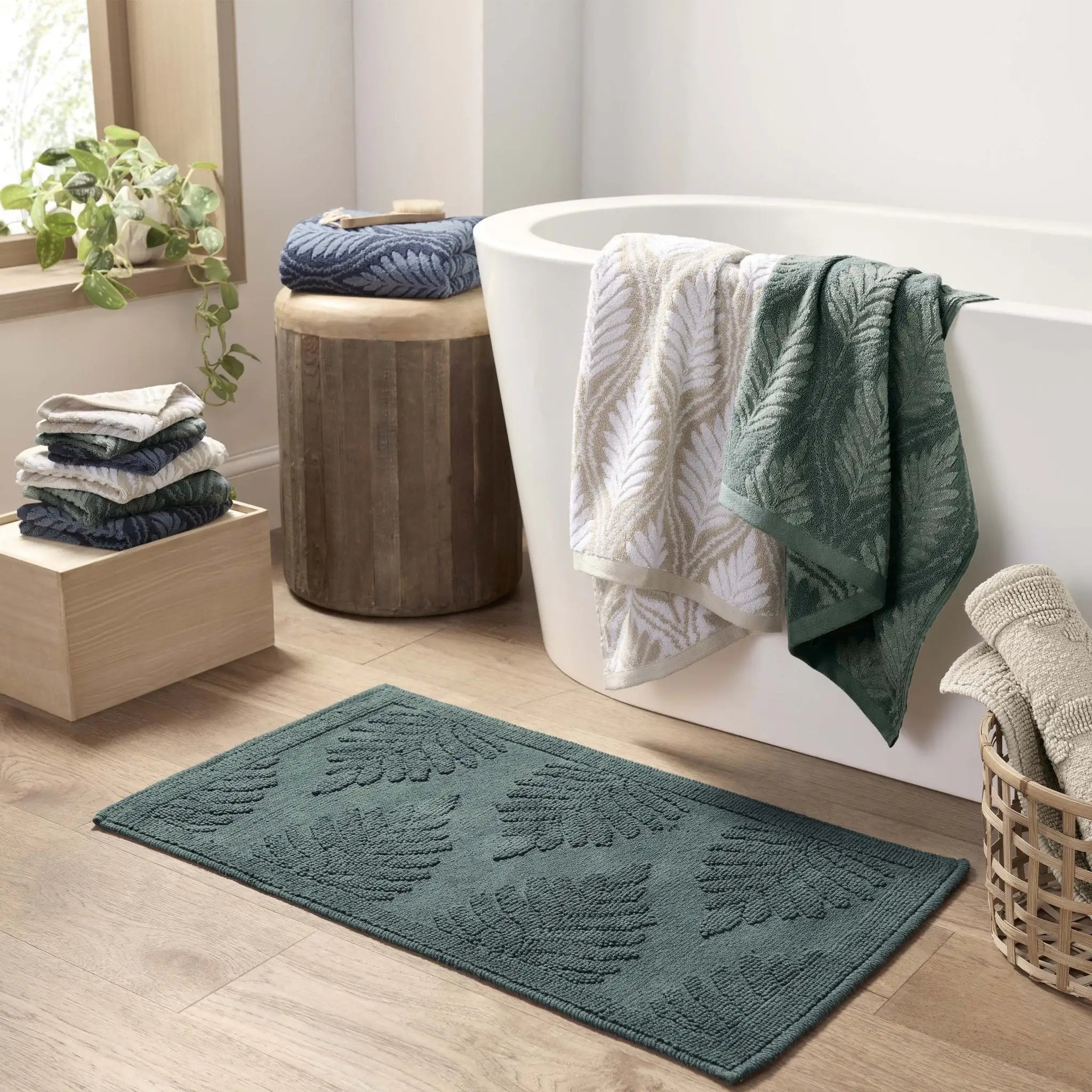 Bathroom with a bath mat, towels, and a bathtub.