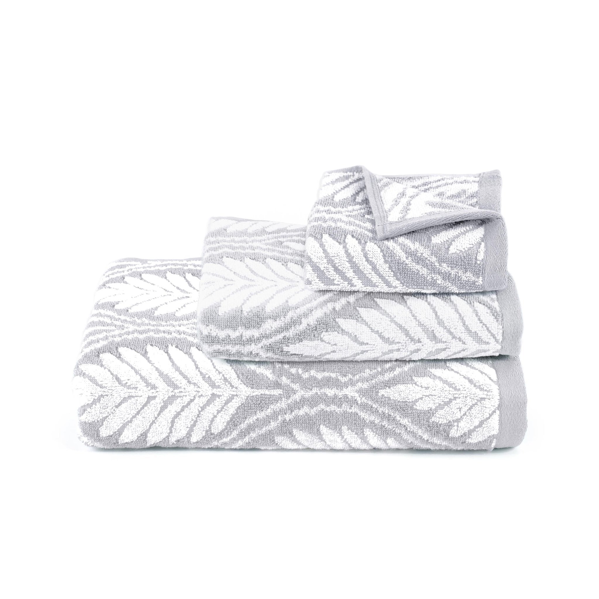 Folded gray towels with white leaf pattern on a white background