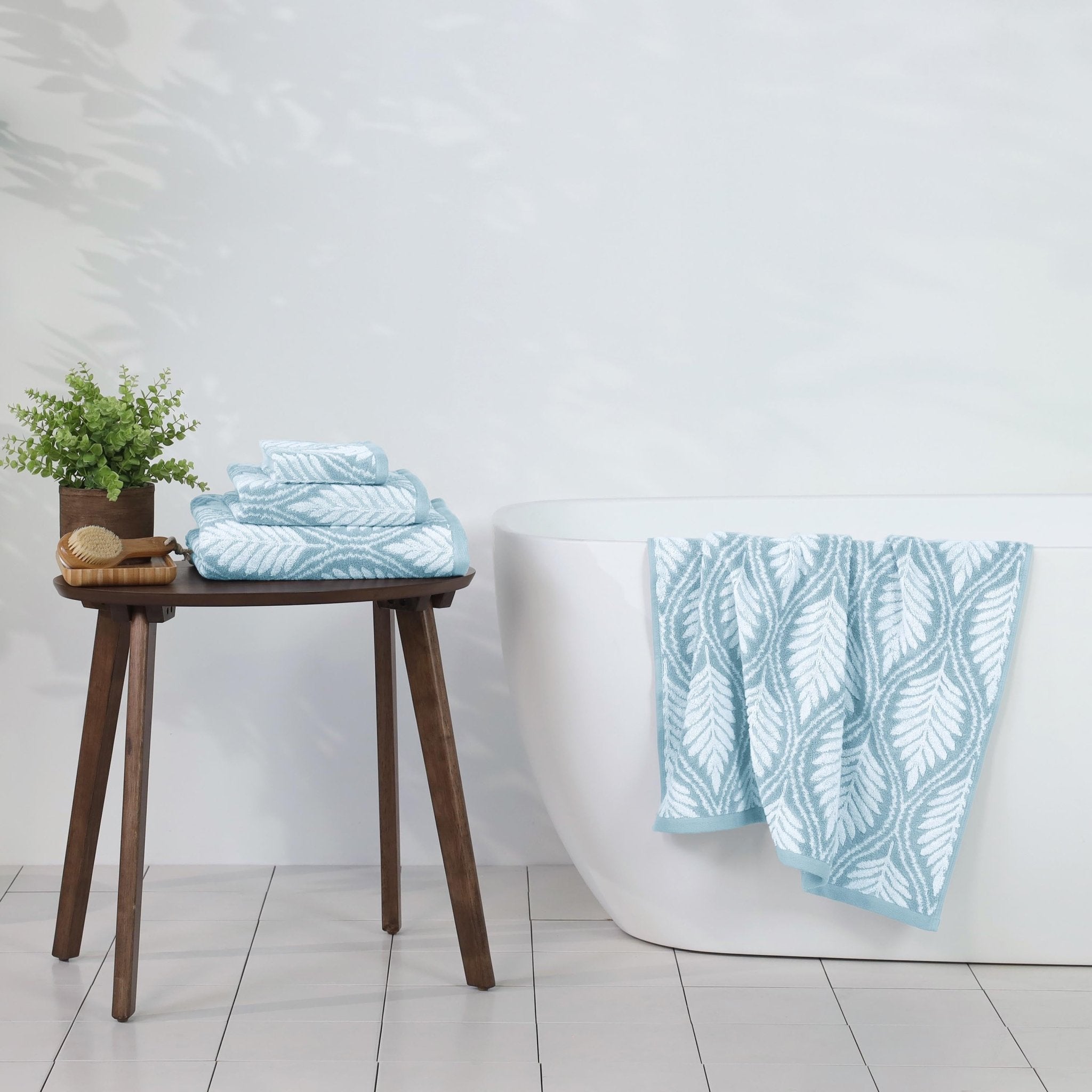 Bathroom setting with mineral patterned towels on a wooden stool and bathtub.