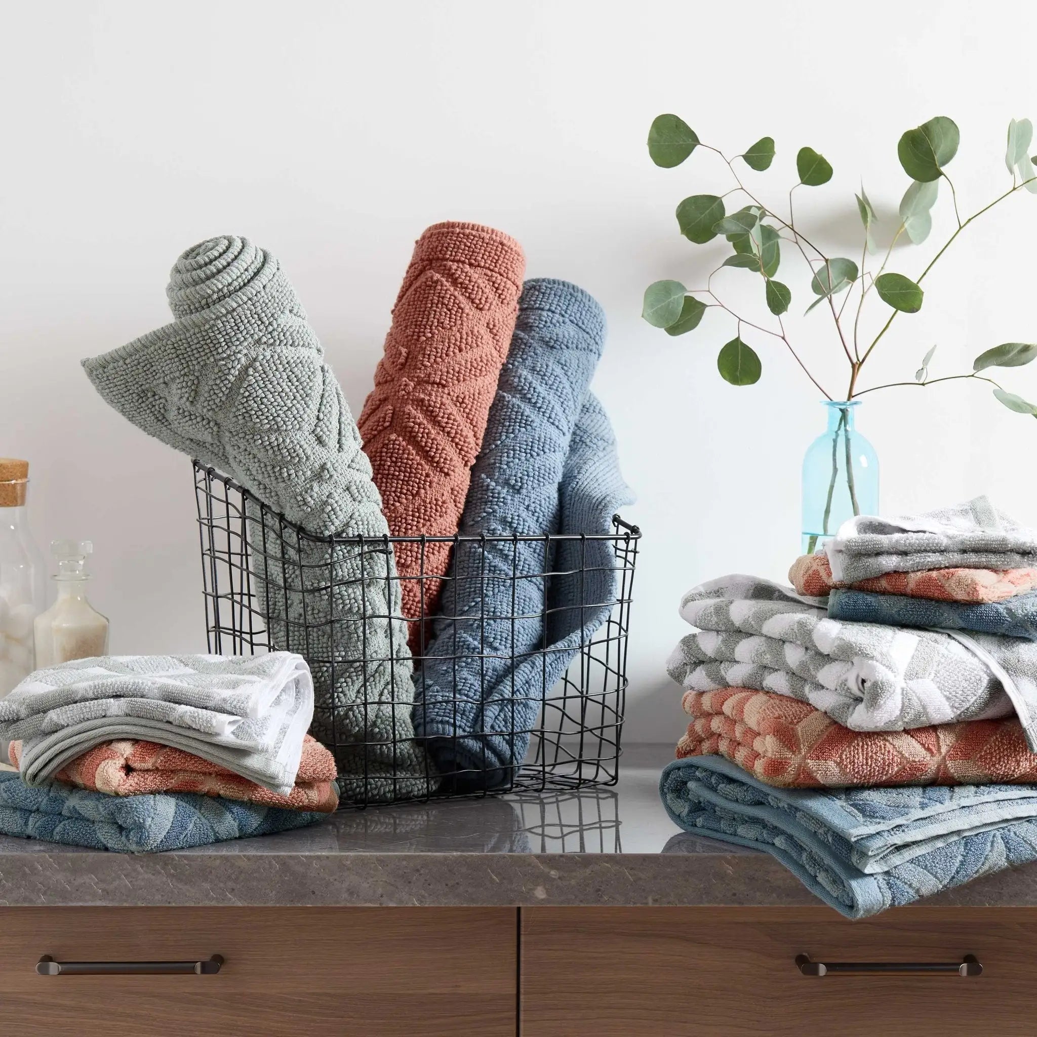 A set of textured bath towels in muted sage, clay, mineral and blue.