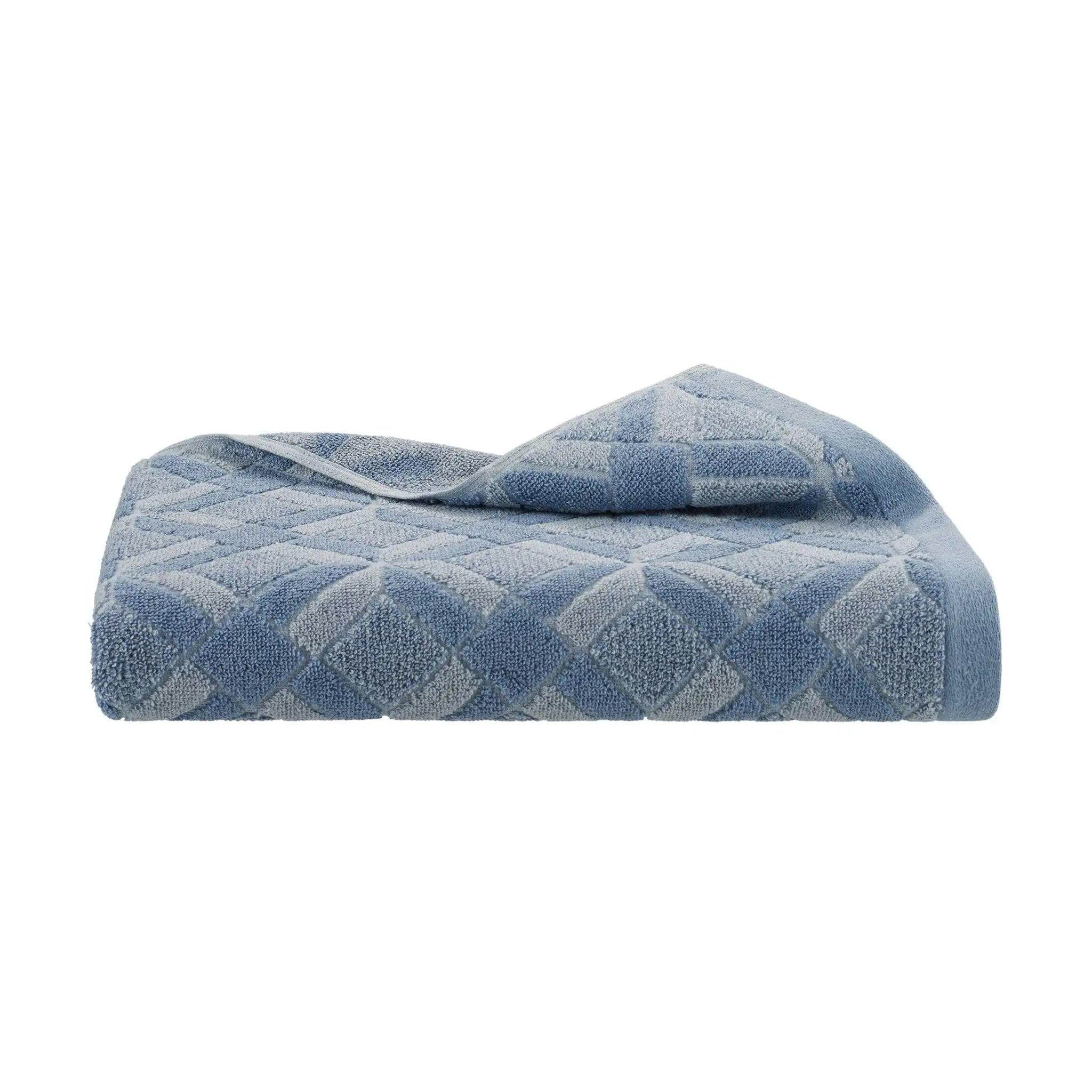 Folded blue patterned bath towel on a white background